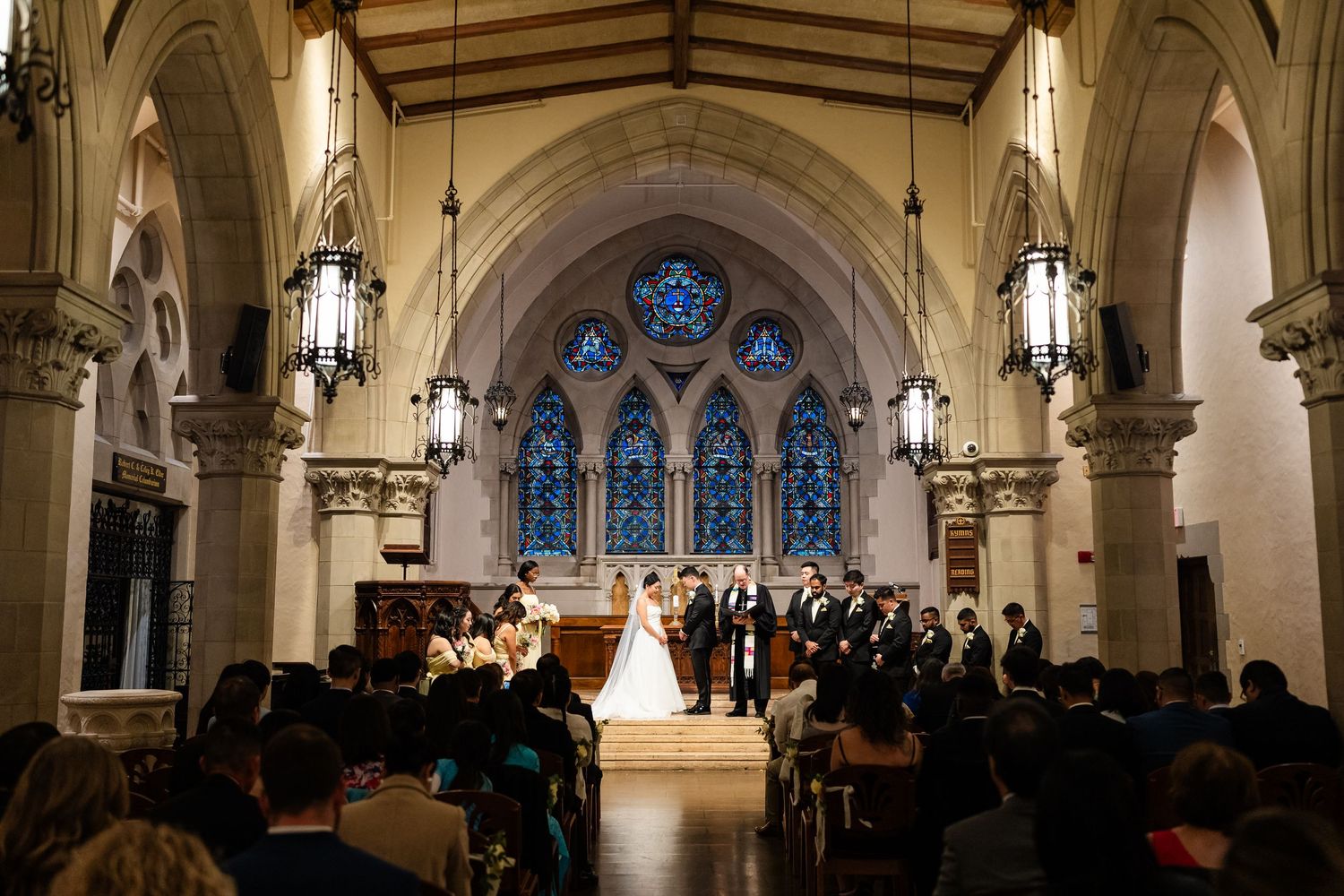 Traditional church wedding ceremony in a gothic cathedral with stained glass windows.
