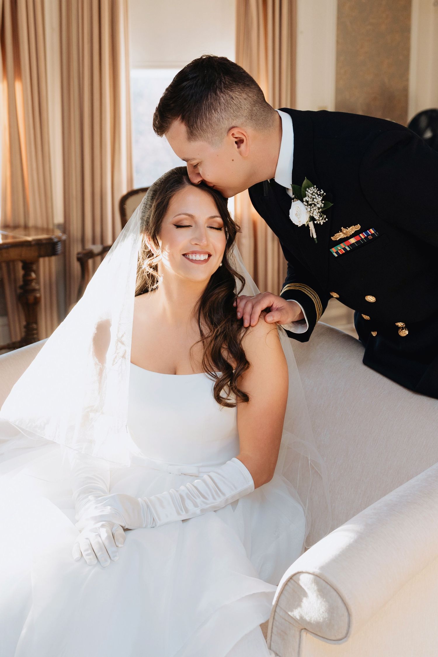 Joyful wedding moment captured in bright interior with flowing white dress and veil.