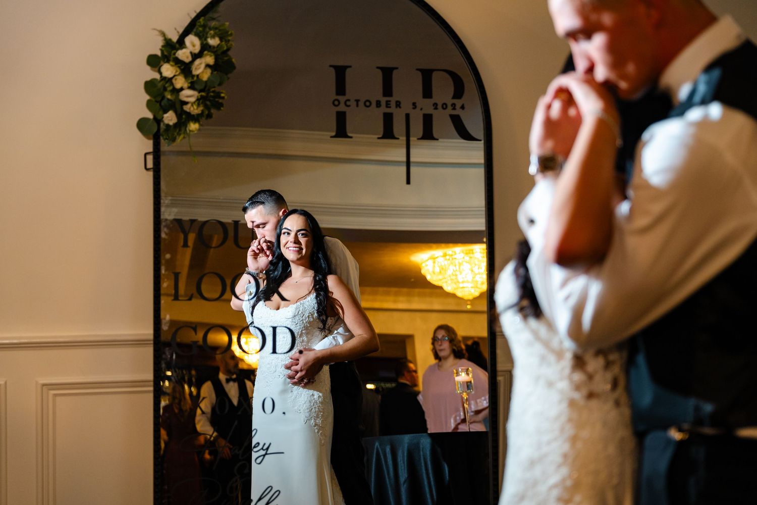 Couple sharing their first dance under an archway at an indoor wedding reception venue.
