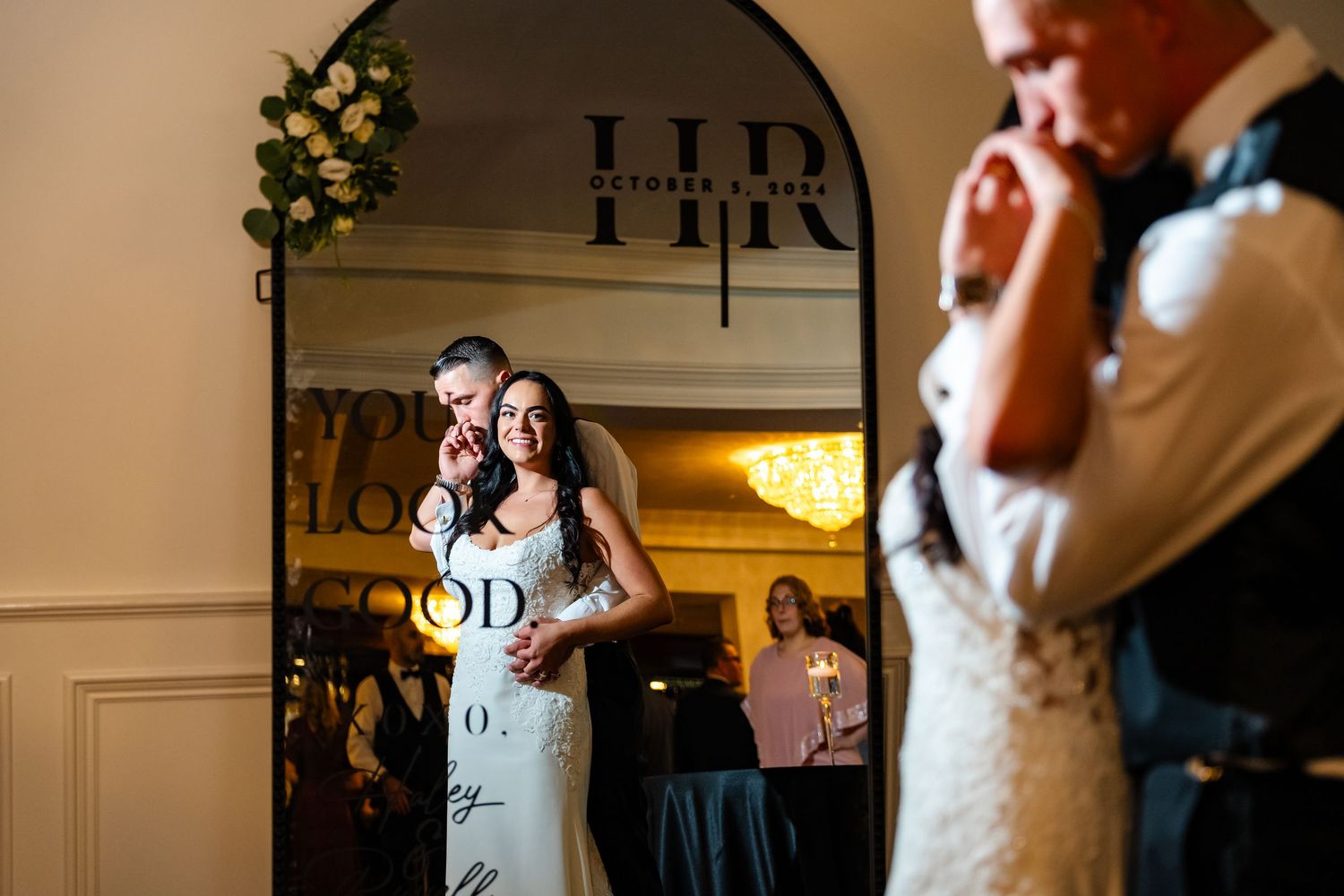 Couples dance together during a romantic wedding reception in a warmly lit ballroom.