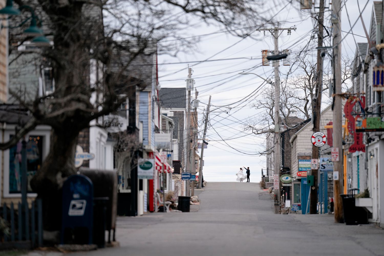 Empty urban street scene in Japan with power lines and buildings under an overcast winter sky.