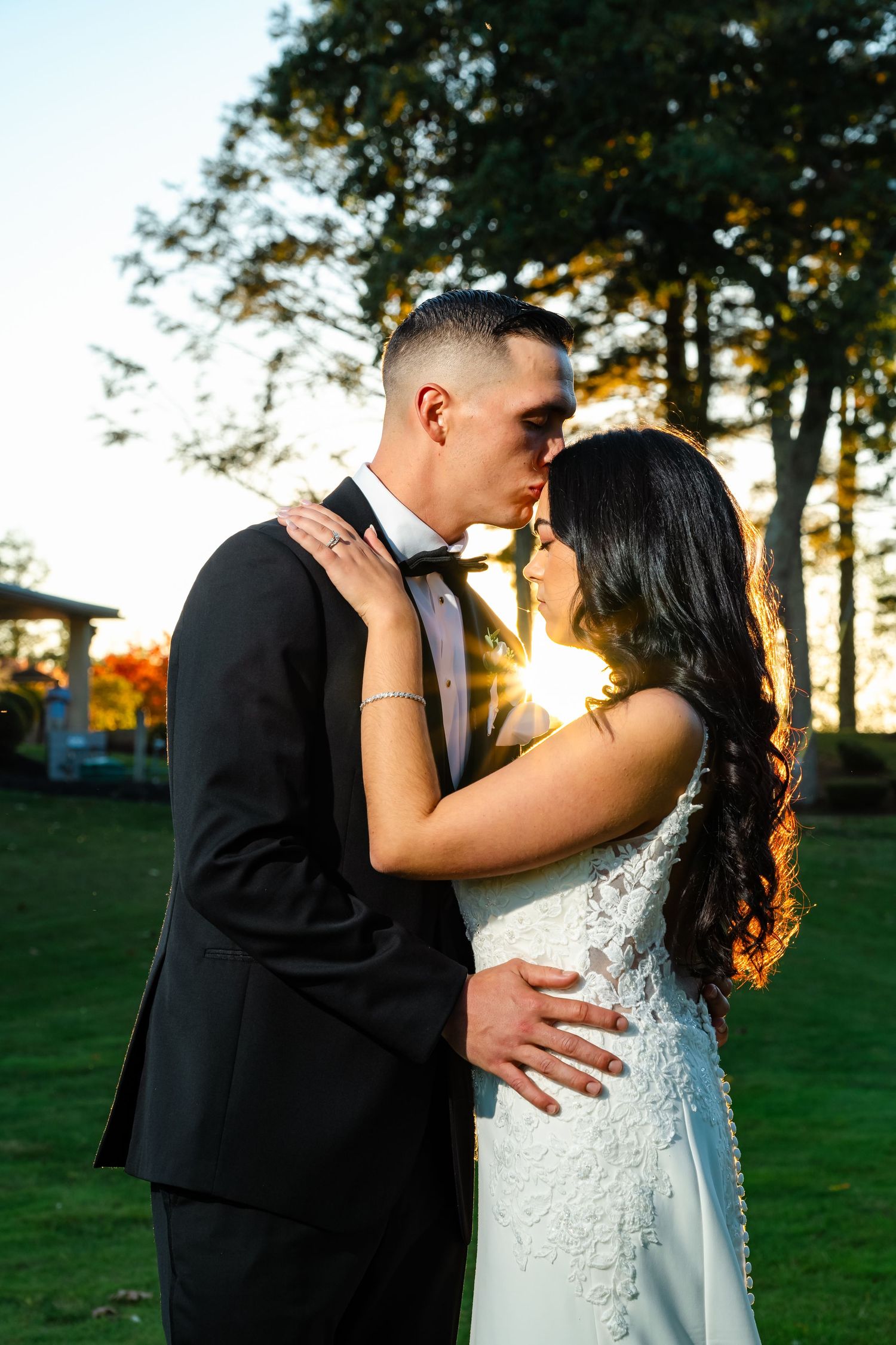 Romantic wedding couple shares intimate kisses in a series of outdoor sunset portraits in a park setting.