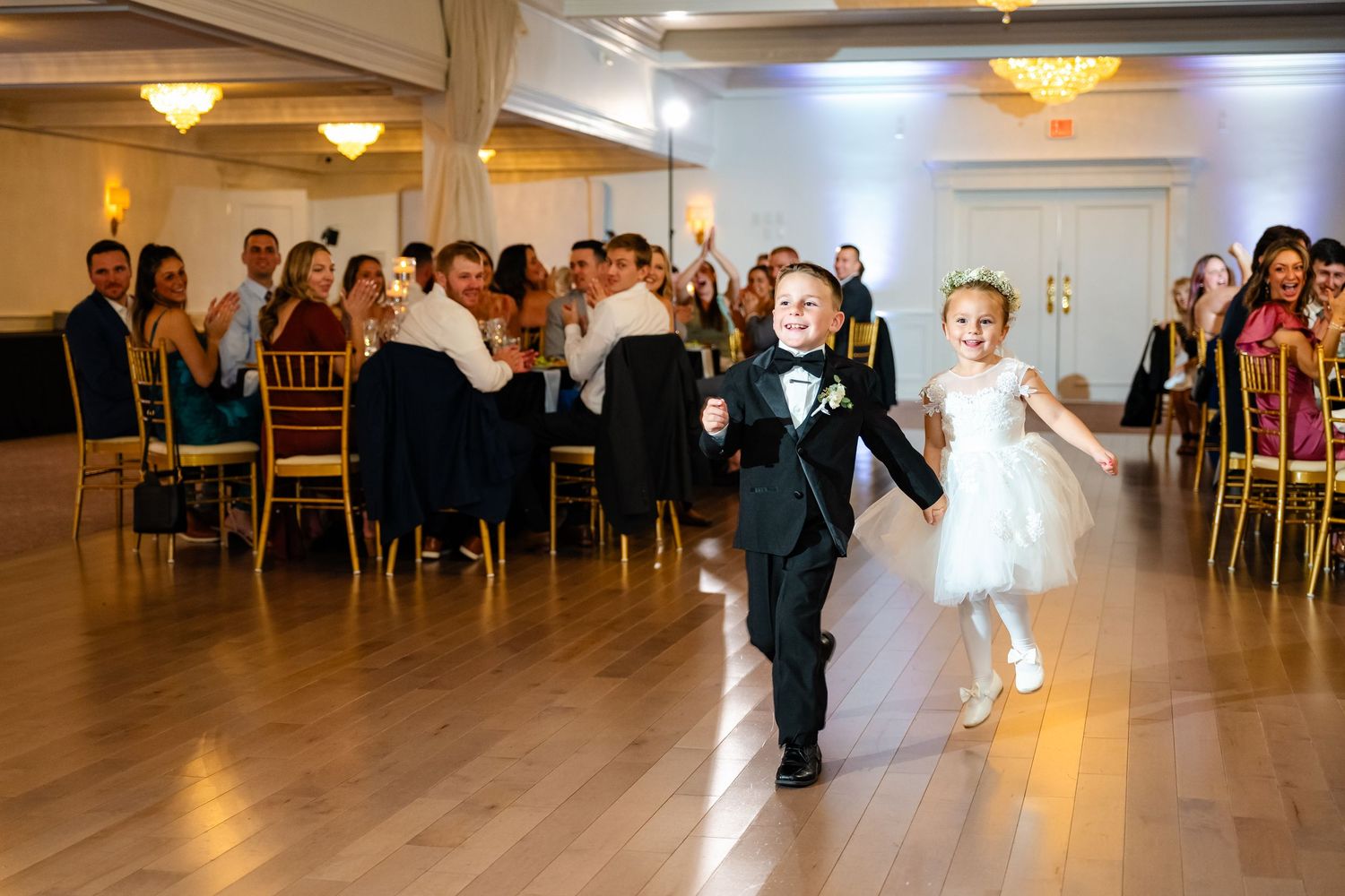 Wedding guests enjoying festivities on the dance floor of an elegant ballroom venue.