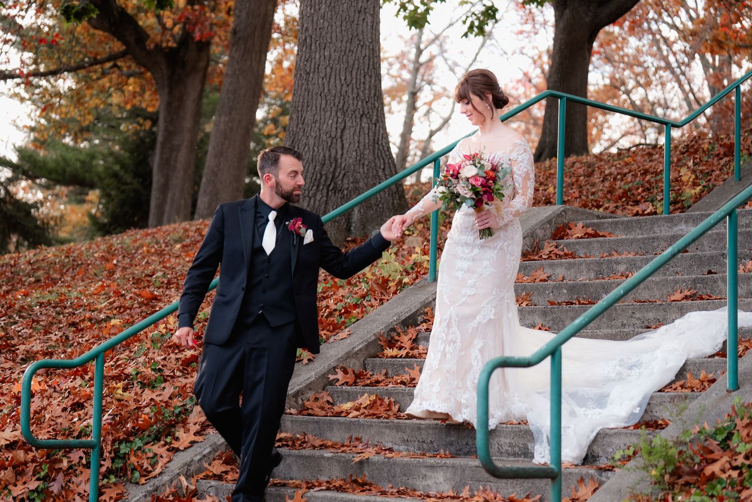 A playful moment captured on rustic outdoor stairs surrounded by autumn foliage.