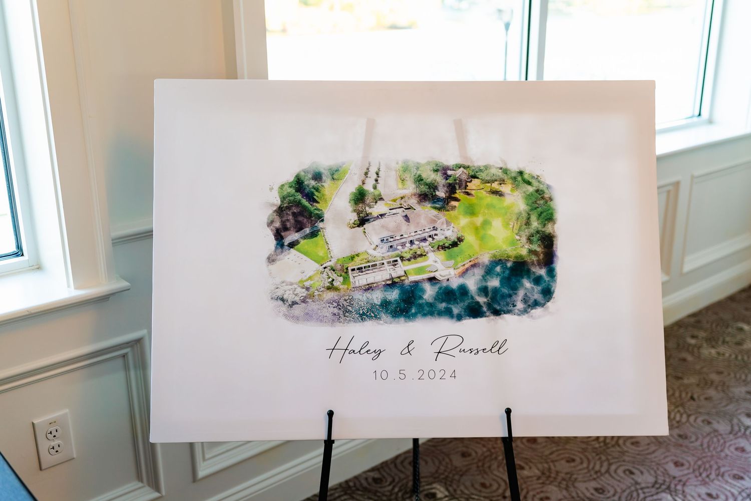 Watercolor wedding sign with blue and green abstract design displayed on white easel.