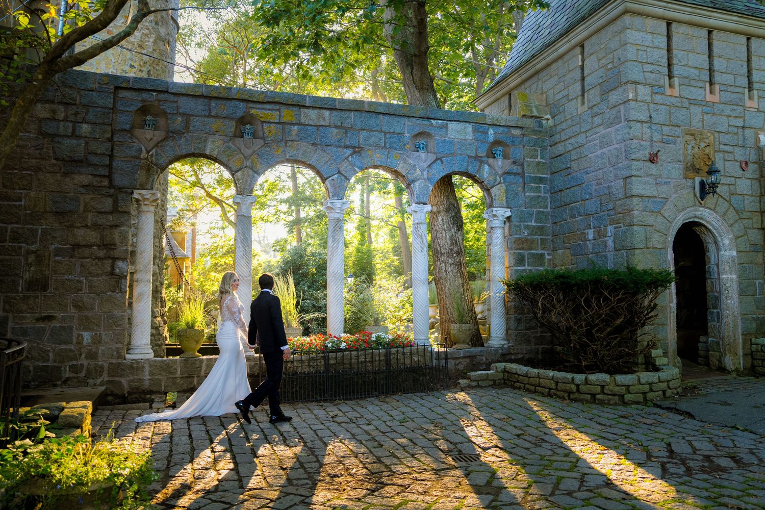 A sunlit stone archway in a castle courtyard creates dramatic shadows and light beams through gothic windows.