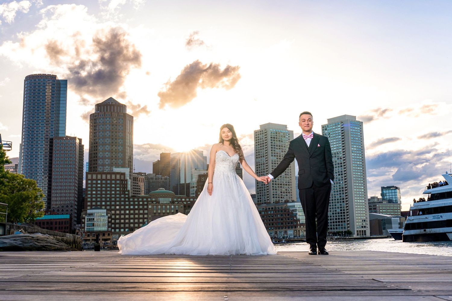 A waterfront engagement session with city skyline and sunset colors in the background.
