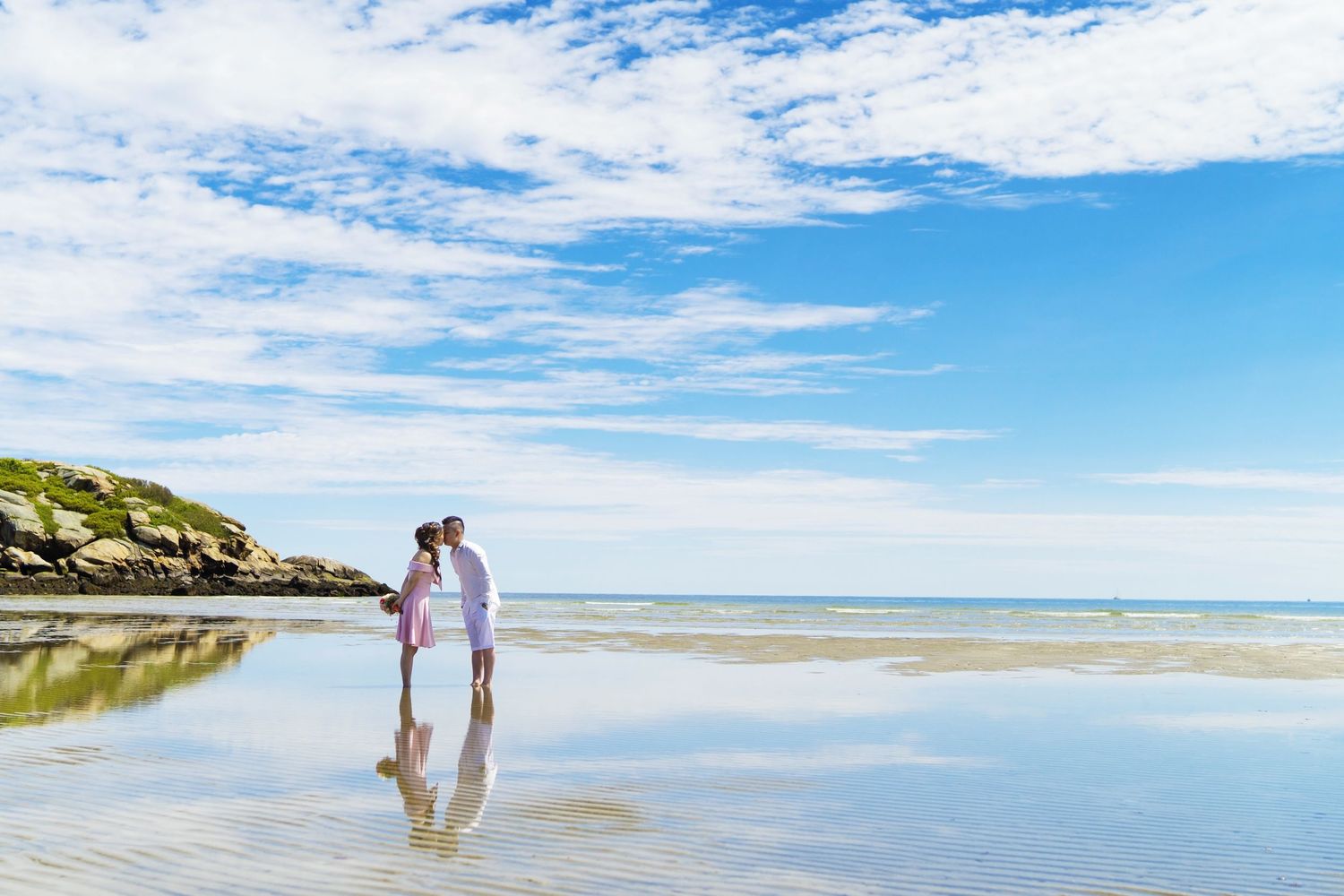 A scenic beach panorama with white sand and blue skies stretches along the coastline.