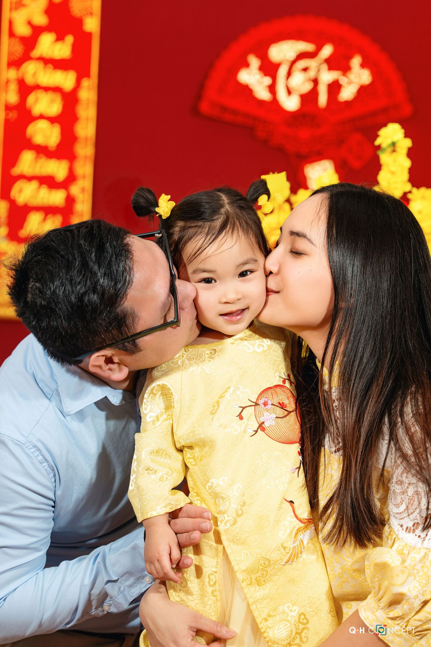 Family shares tender moments during Chinese New Year celebration with red and gold decorations.