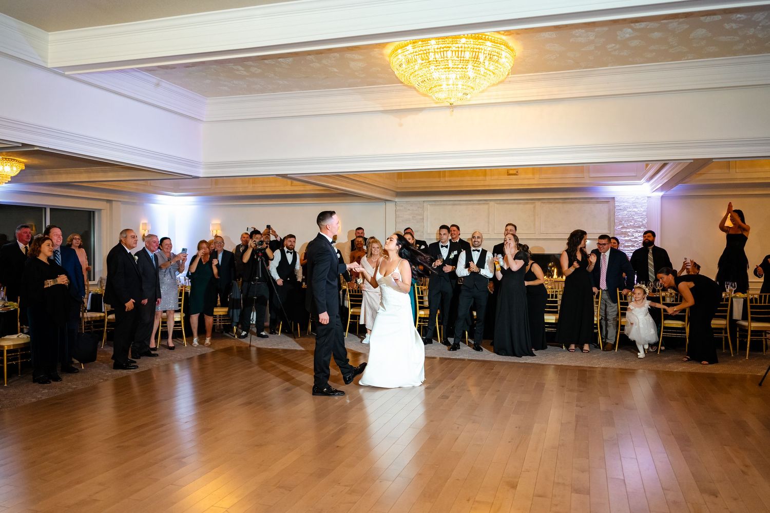 Panoramic view of a wedding reception venue with elegant lighting and formal table settings.