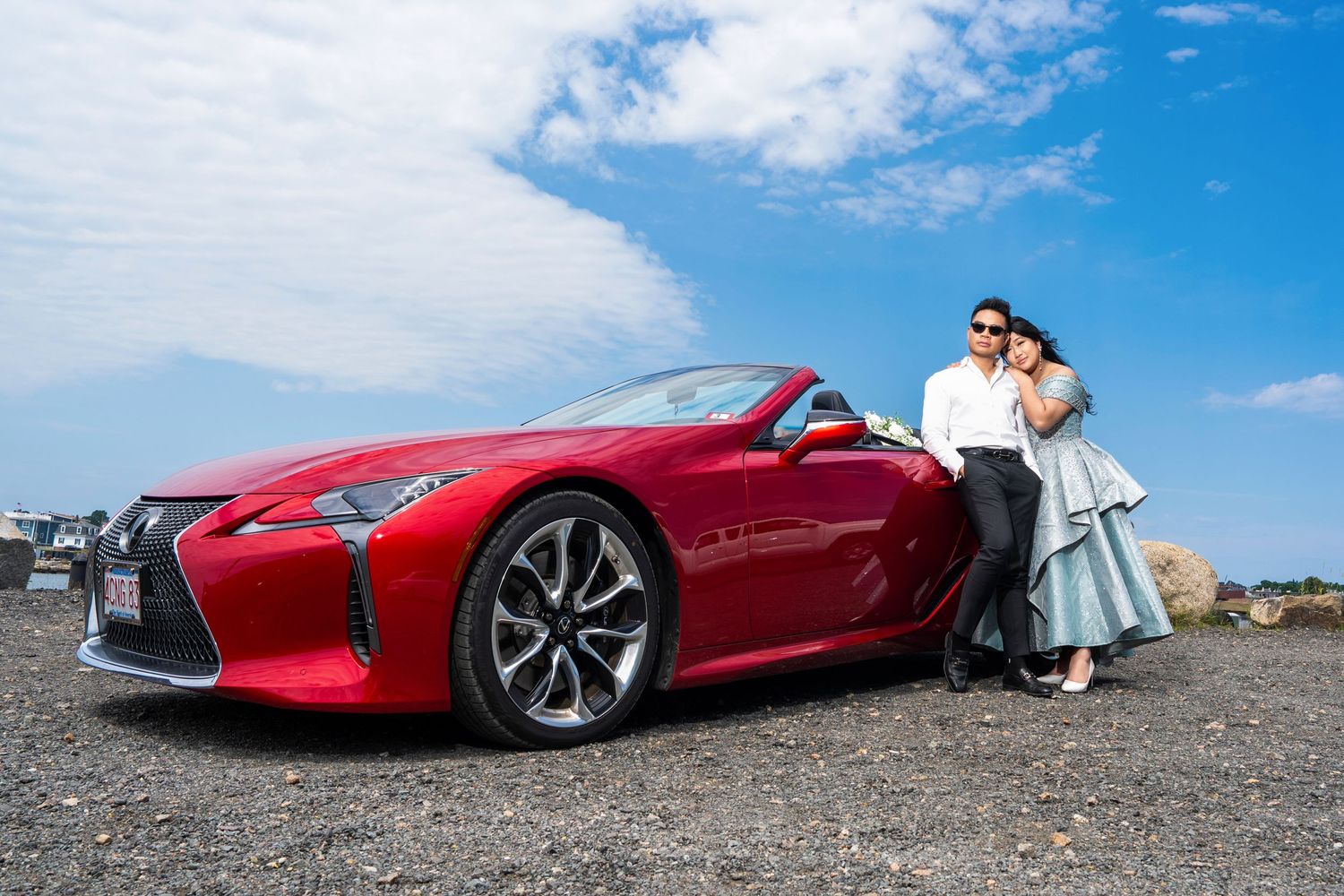 A sleek red sports car parked on a coastal road with dramatic ocean views.