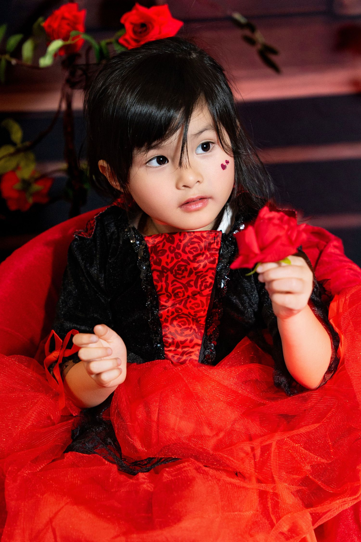 A festive portrait featuring a red and black dress with roses in an elegant setting.