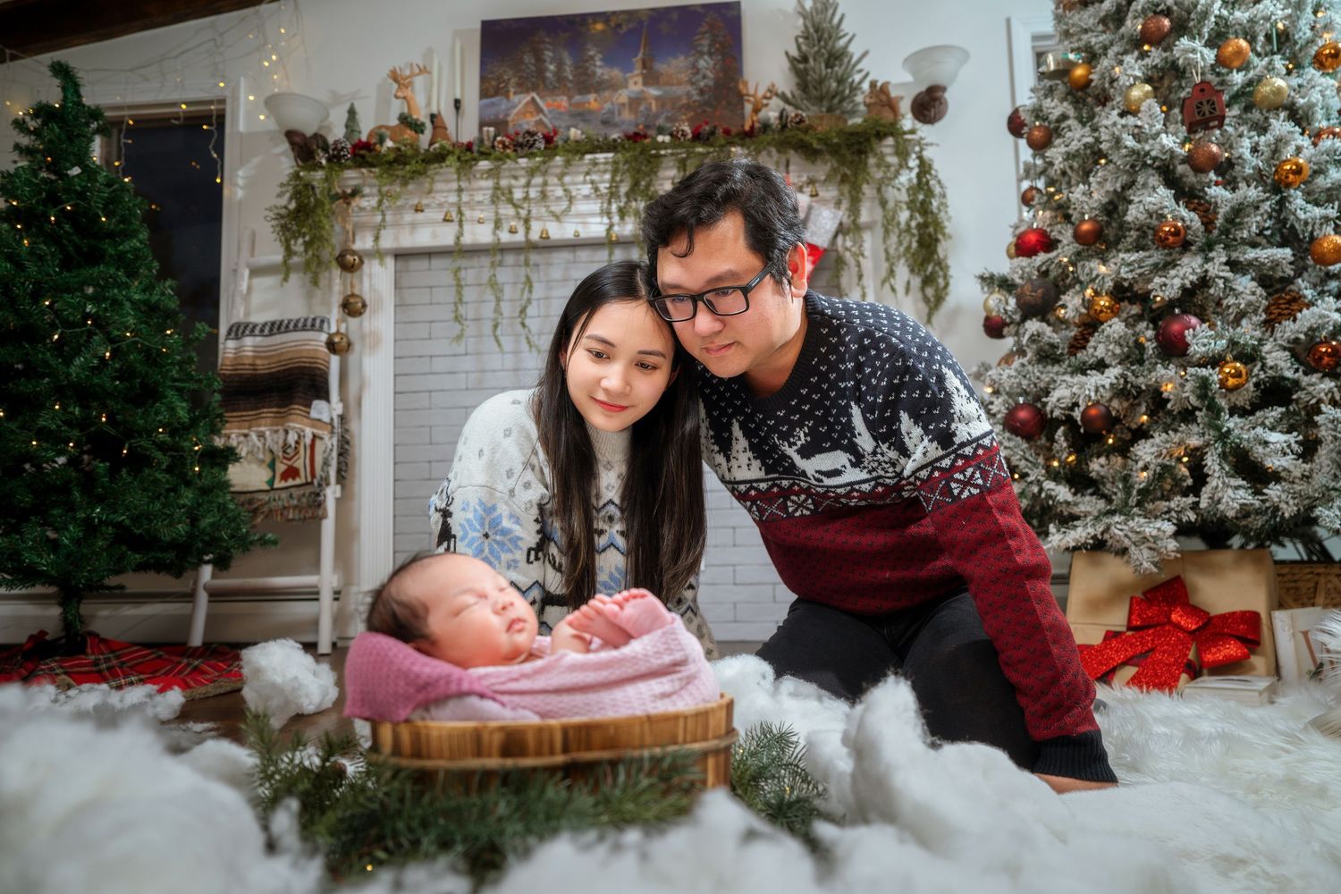 A festive Christmas photo session with a decorated tree, faux snow, and a cozy fireplace backdrop.