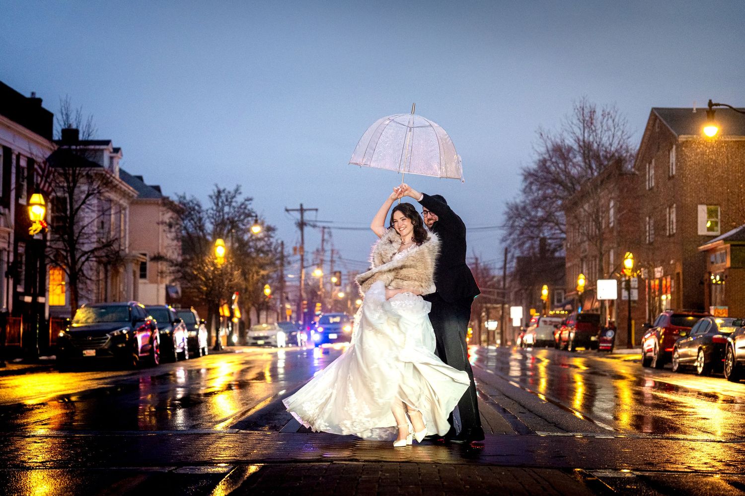 Dramatic nighttime wedding photos on rain-slicked streets with urban lighting.