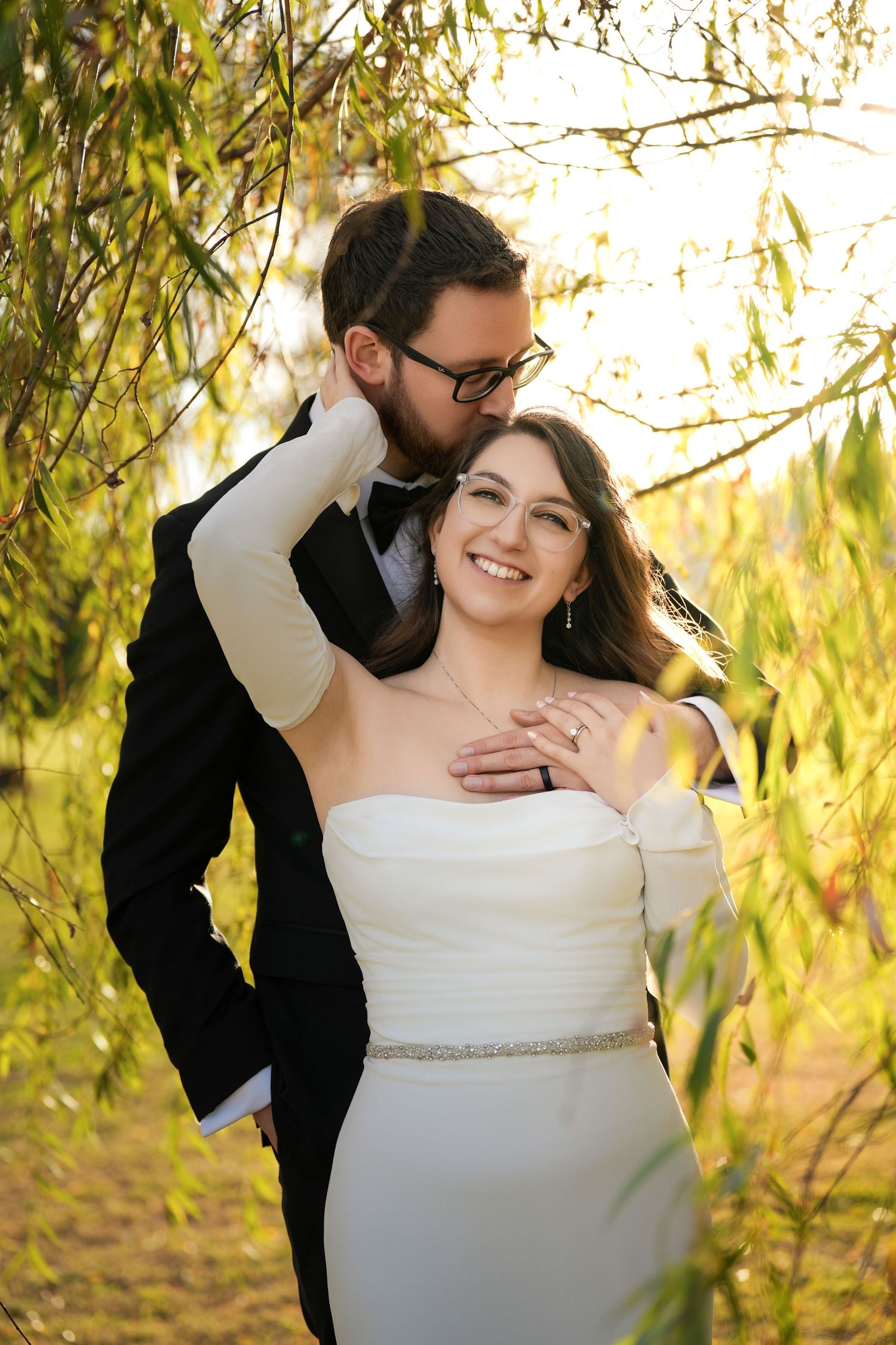 Intimate wedding portraits captured under sunlit willow branches.