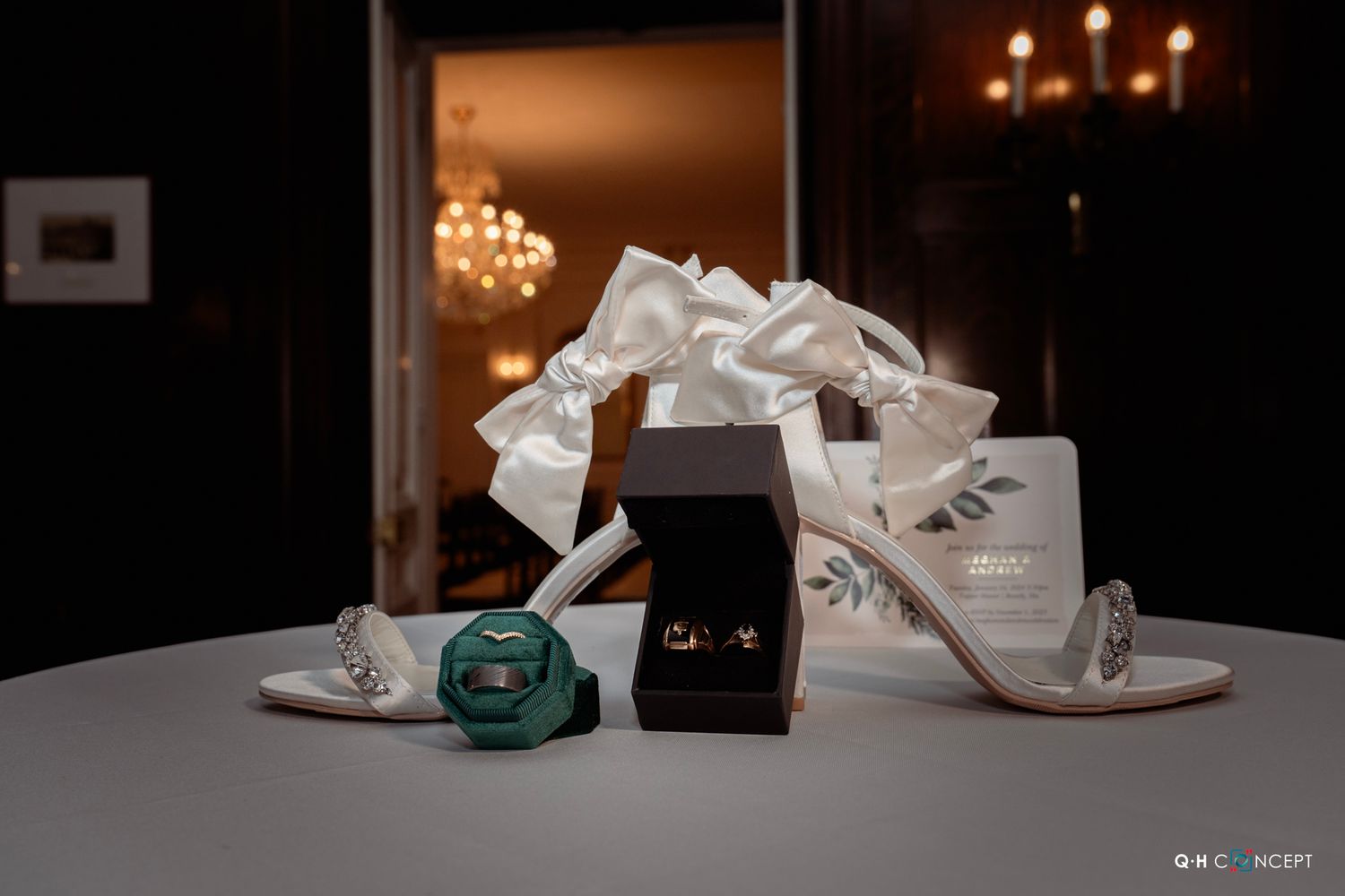 Wedding accessories including white heels, rings, and decorative elements arranged on a table.