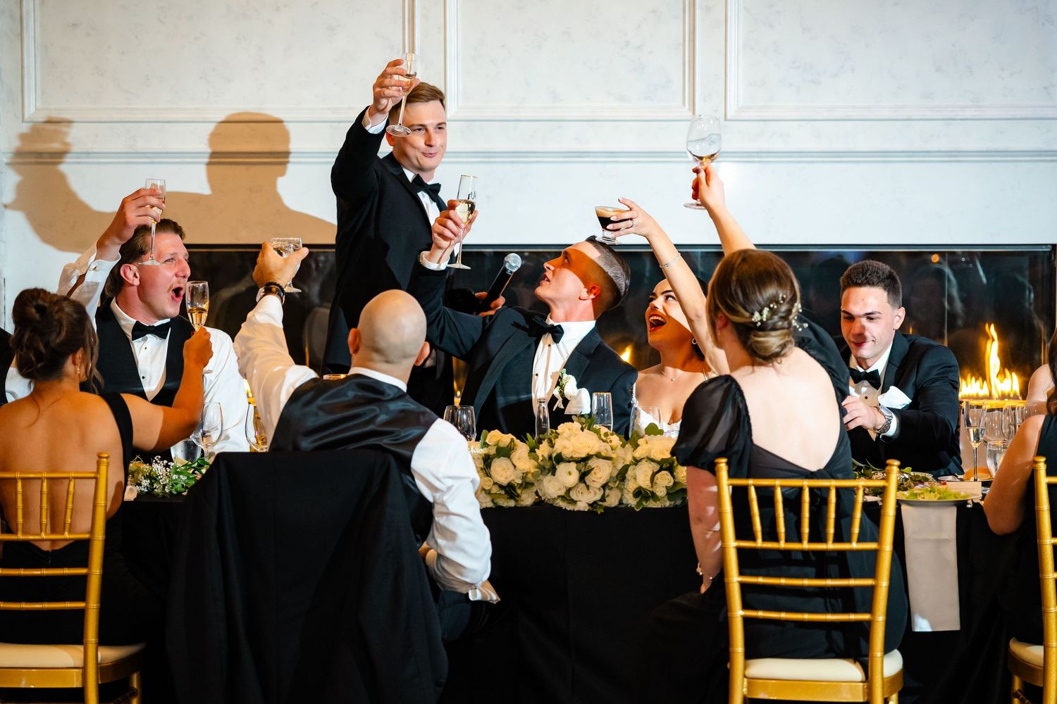 Wedding reception banquet hall with long tables, gold chairs, and elegant decor for formal dining.