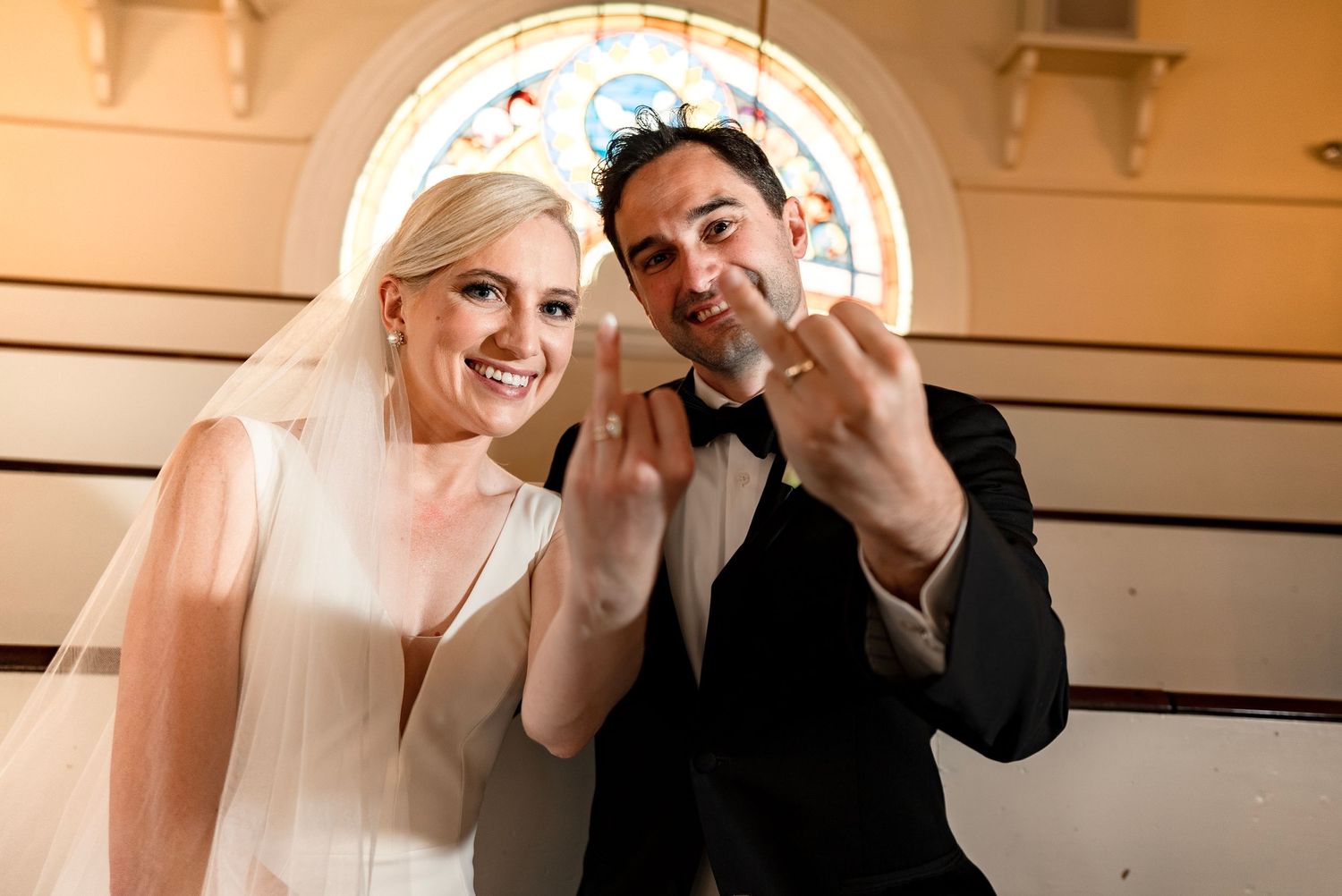 Romantic wedding moment captured under an elegant archway with warm lighting.