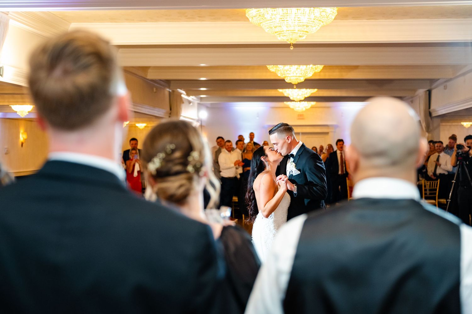 Wedding reception dance floor with guests celebrating and dancing in an elegant ballroom setting.