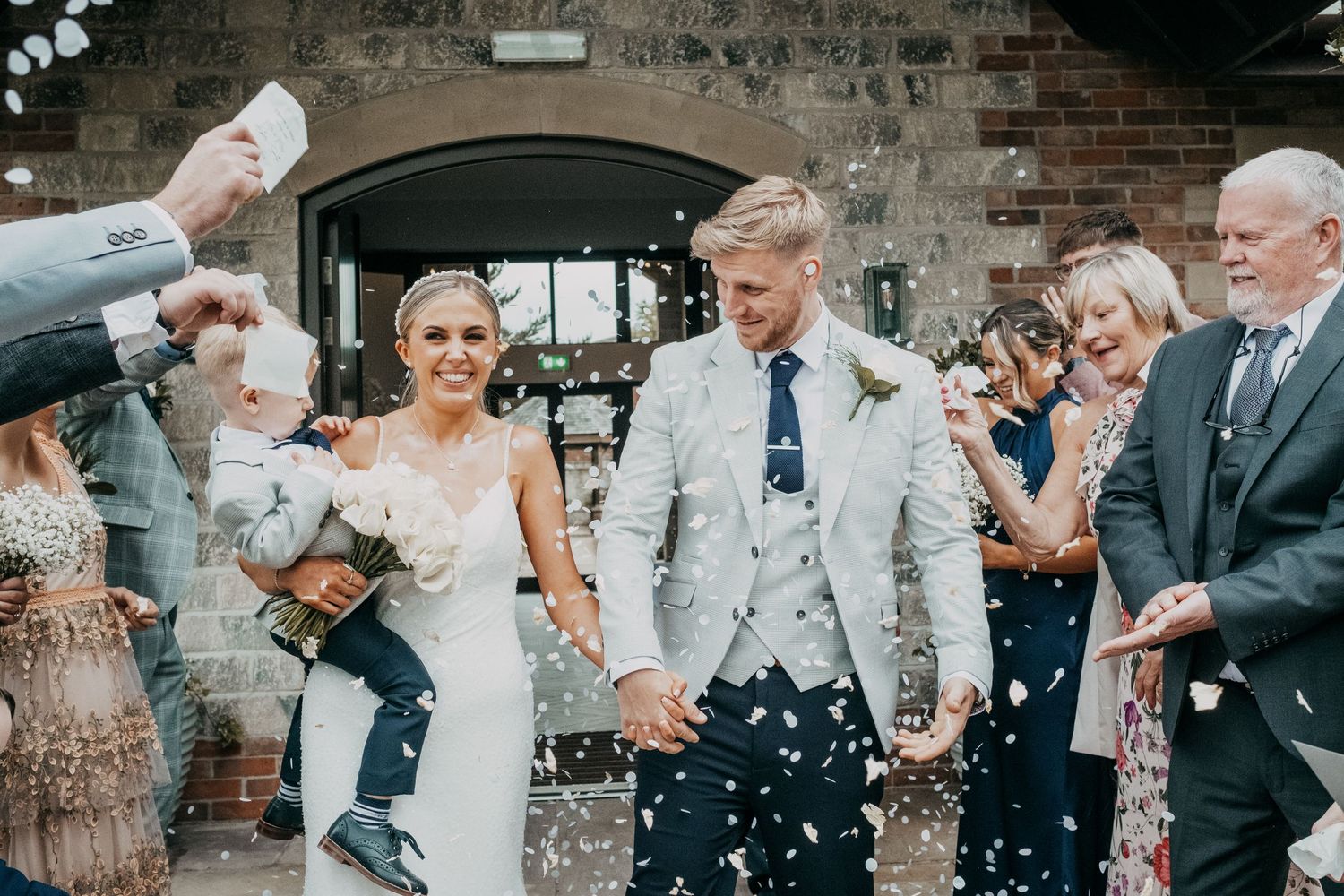 Newlyweds walking back down the aisle smiling  Burntwood Court hotel