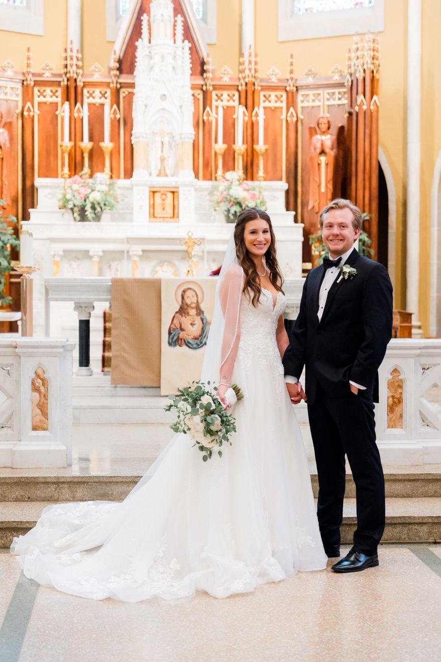 Elegant church wedding ceremony with peach walls, white altar, and classic decor.