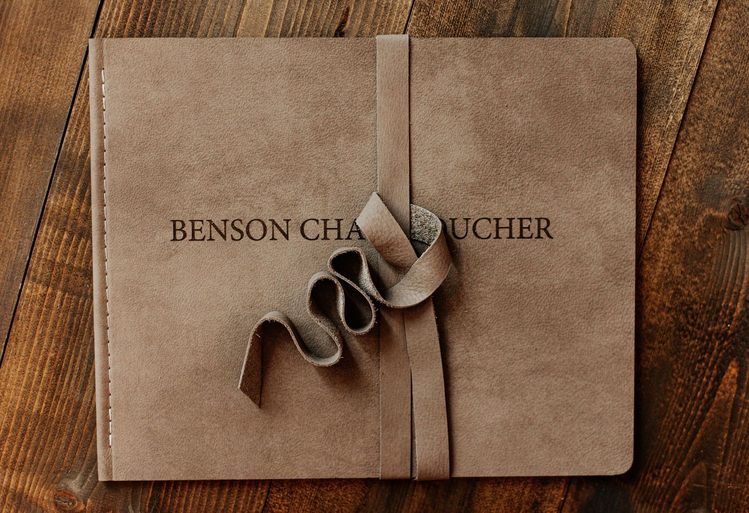 Professional photographer's portfolio book with elegant ribbon detail and embossed text.