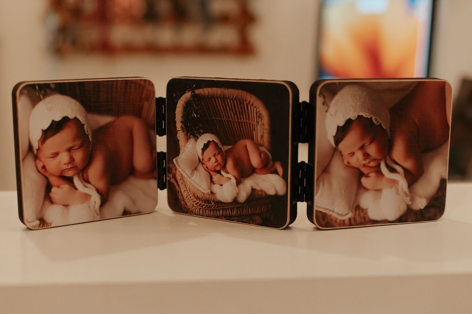 Triptych folding photo frame displaying three artistic newborn portraits.