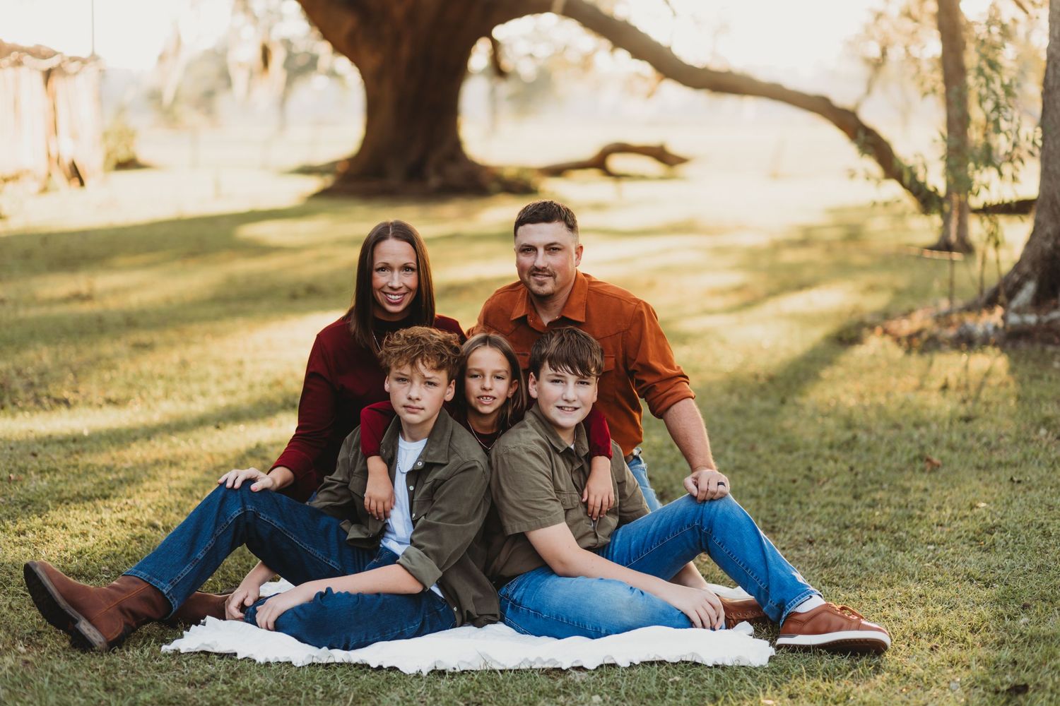 Modern family photo session showing playful poses on white blanket outdoors.