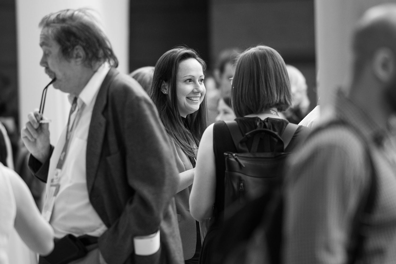 Black and white photo of people mingling and socializing at an elegant event or gathering.
