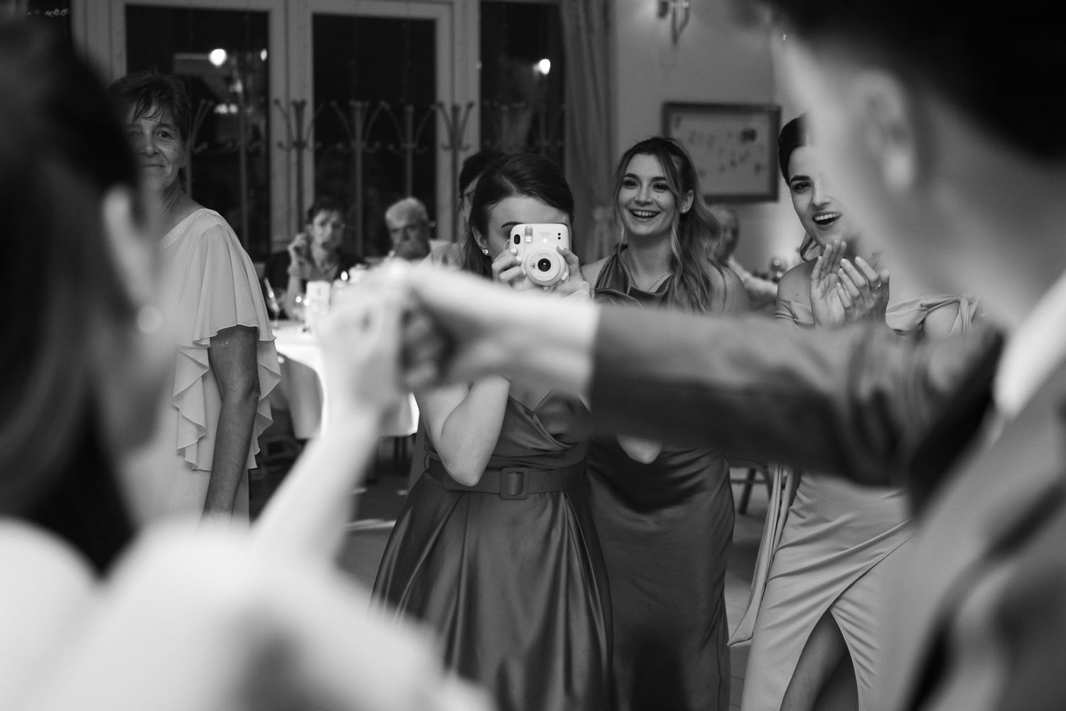 Wedding guests dancing and celebrating on a crowded dance floor.