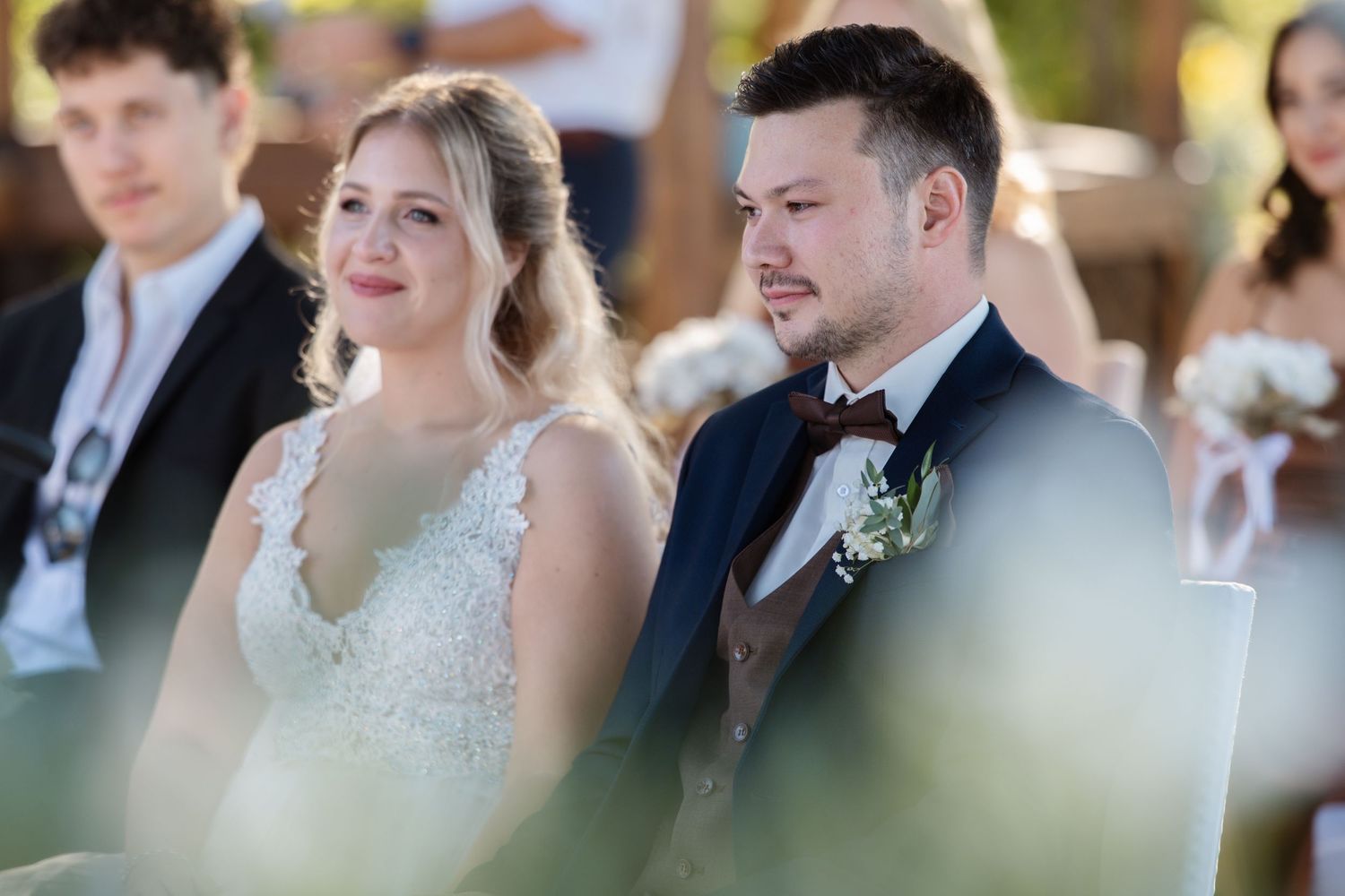 Wedding guests seated during outdoor daytime ceremony.