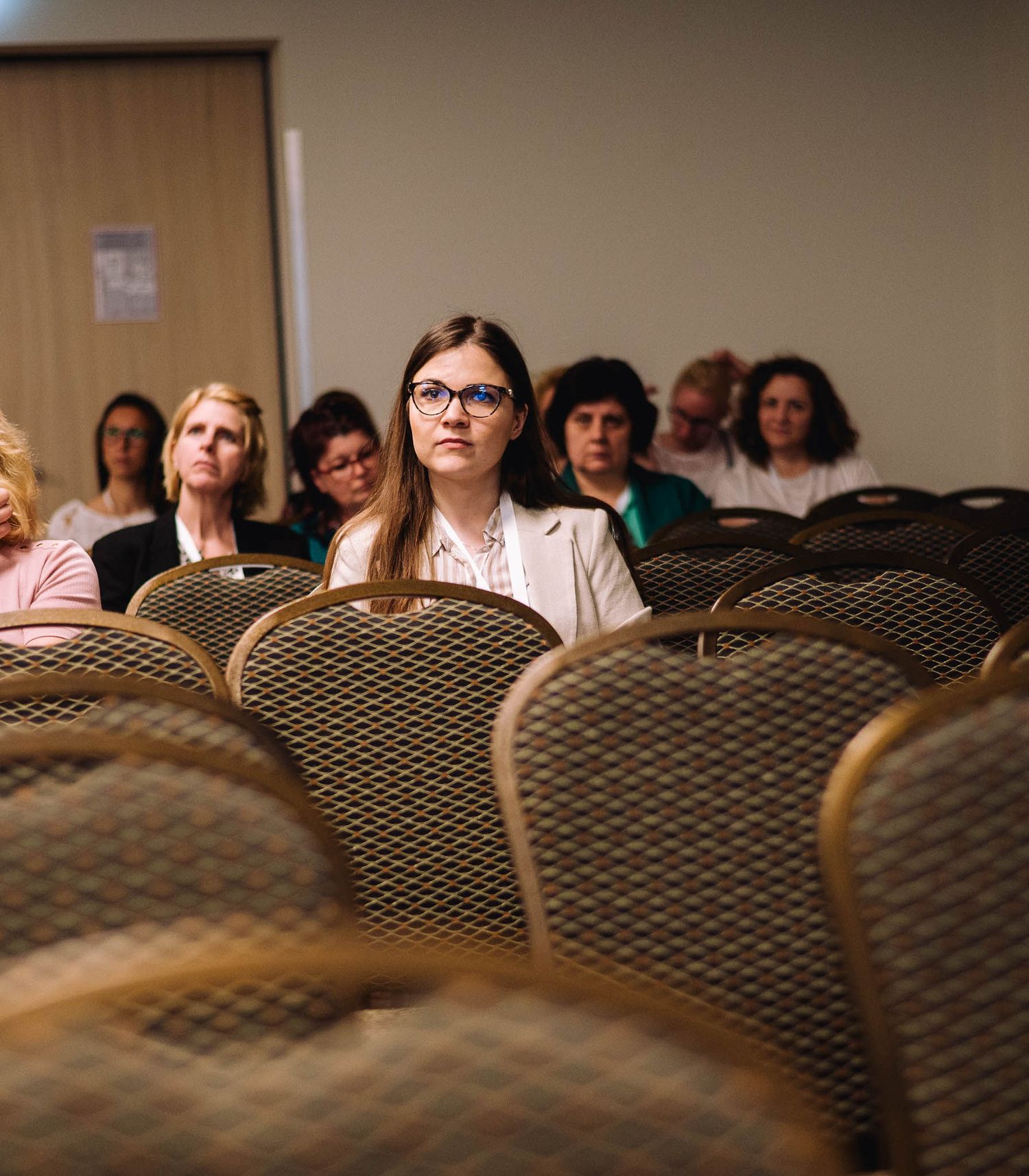 Row of patterned conference chairs shown from a creative angle during an indoor event.