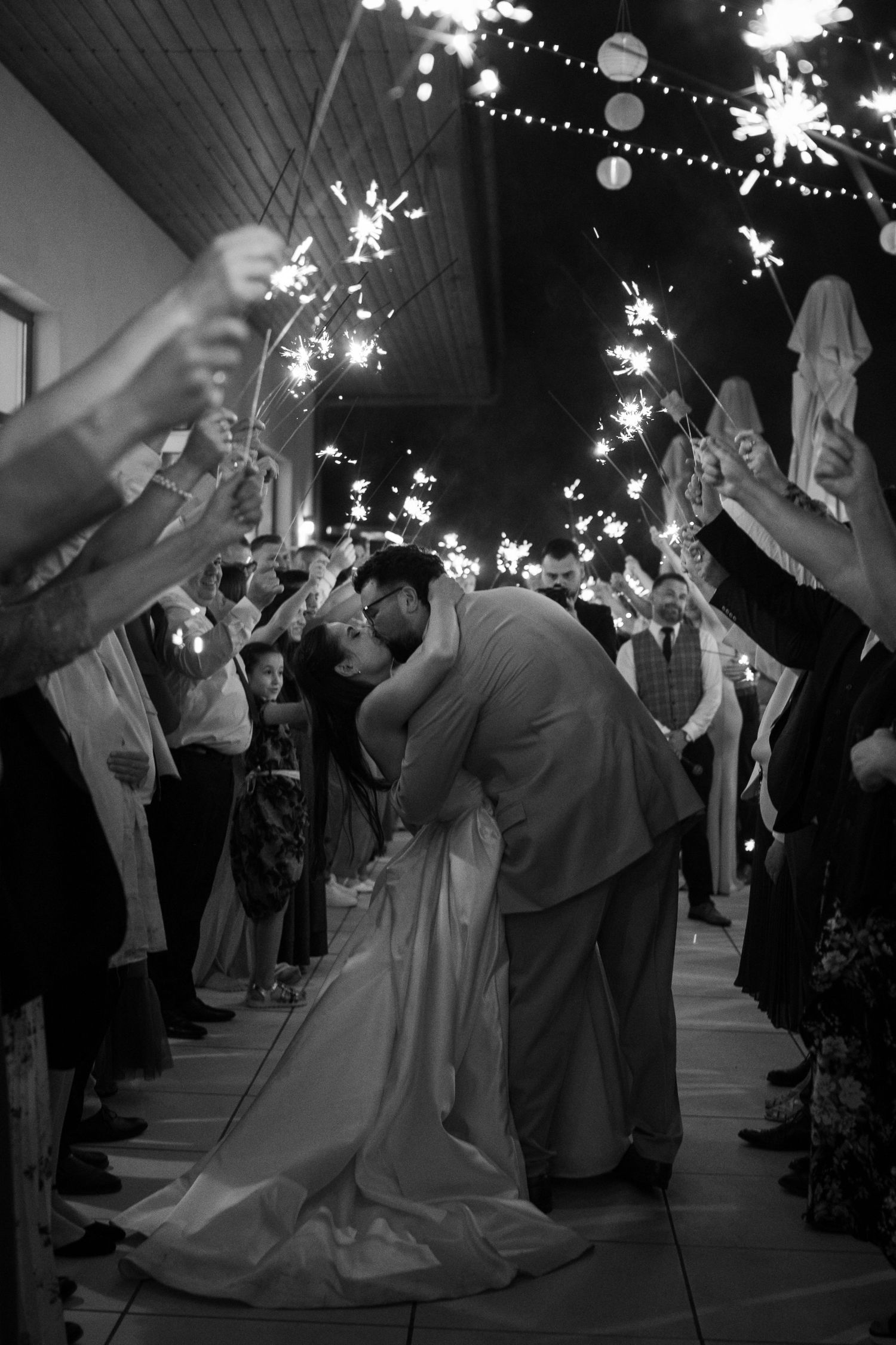 Wedding guests holding sparklers during an evening celebration.