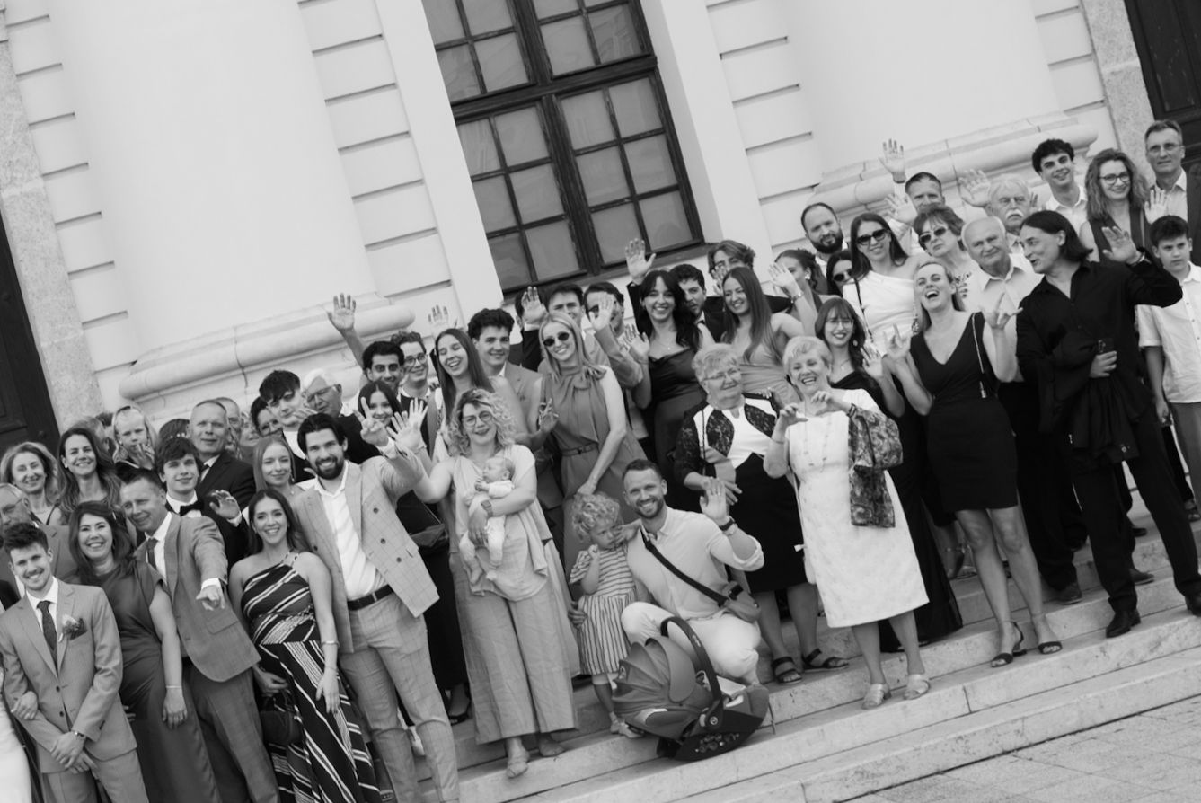 Large group of people posing on building steps in black and white photo, celebrating at a formal outdoor event.