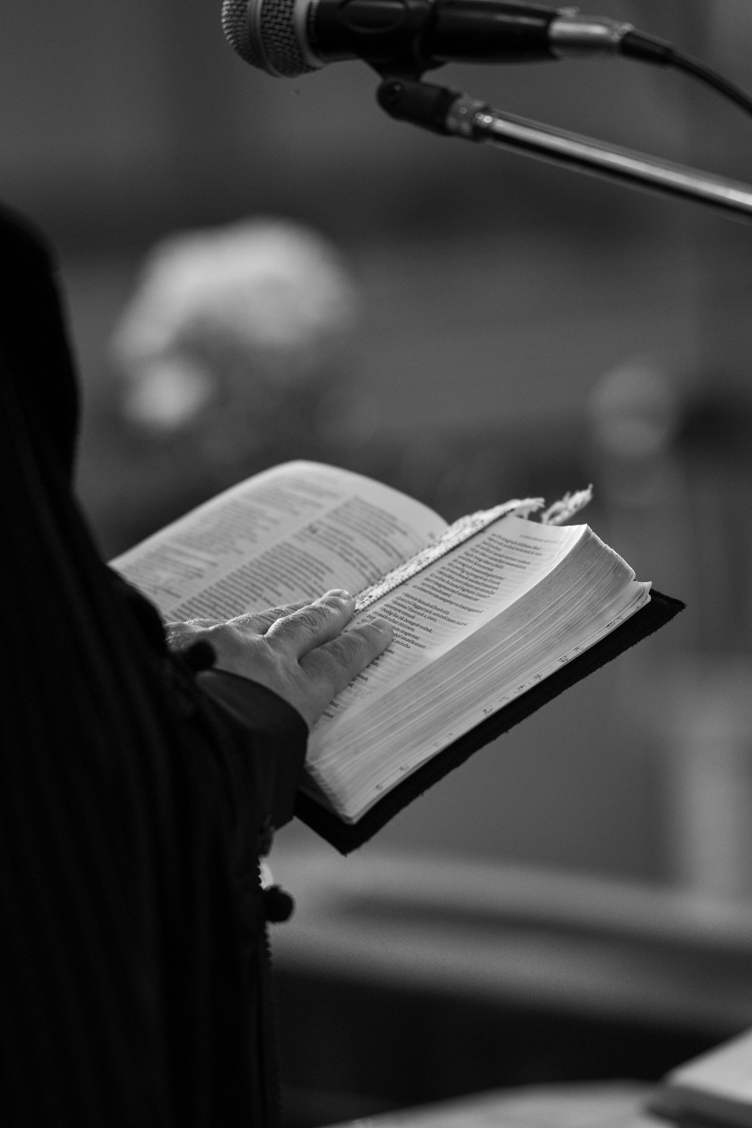 Black and white image of an open Bible during a wedding ceremony.