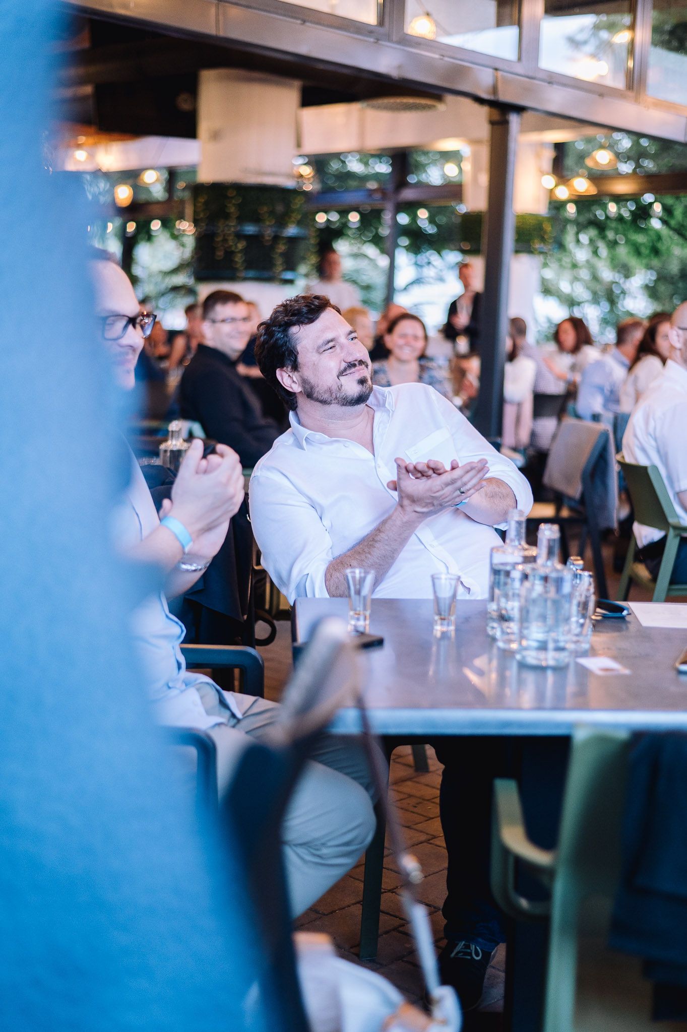 Candid shots of networking and conversation at an evening business event.