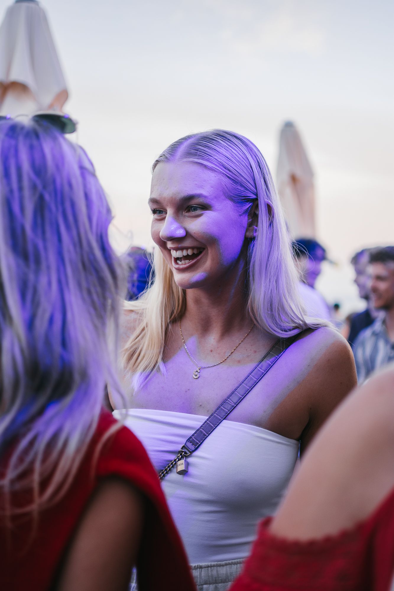 People with colorful hair enjoying a festive outdoor celebration.