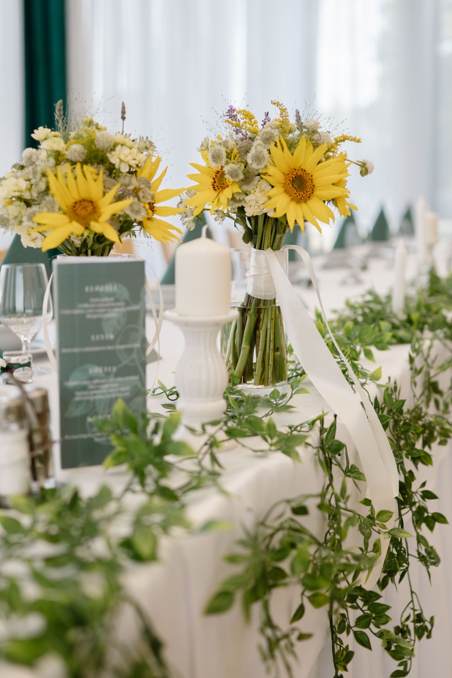 Wedding reception tables decorated with bright yellow sunflower centerpieces and white linens.