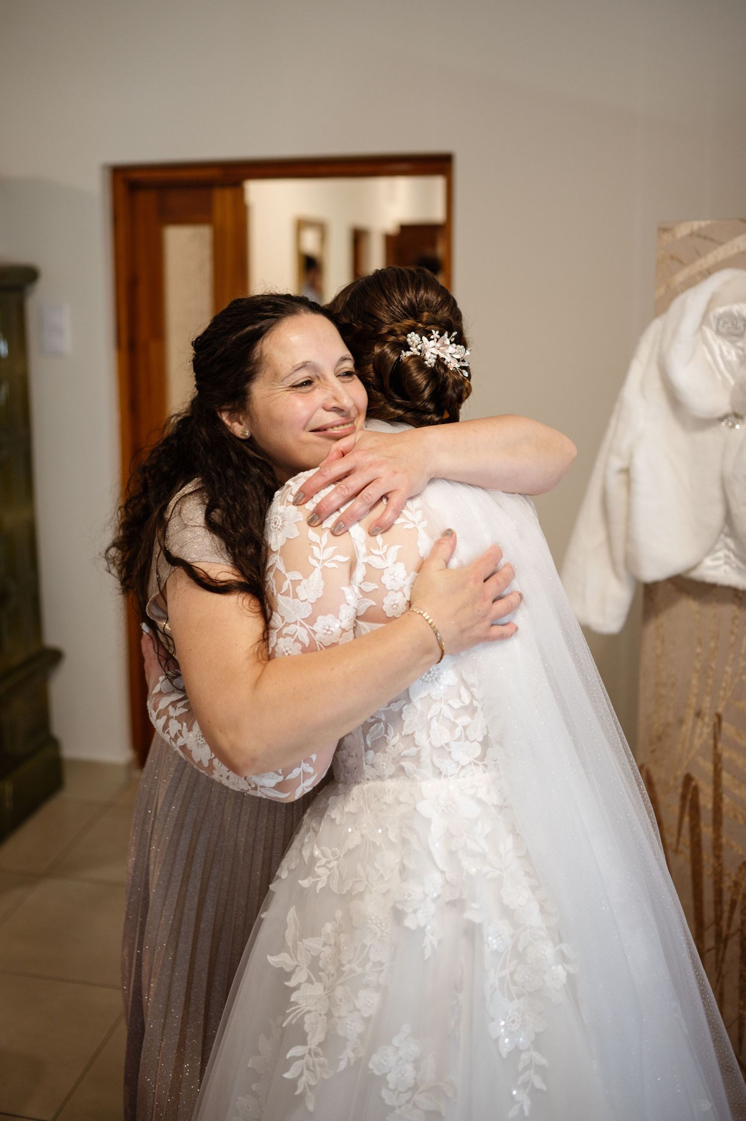 Emotional moment of wedding guests embracing in formal attire.
