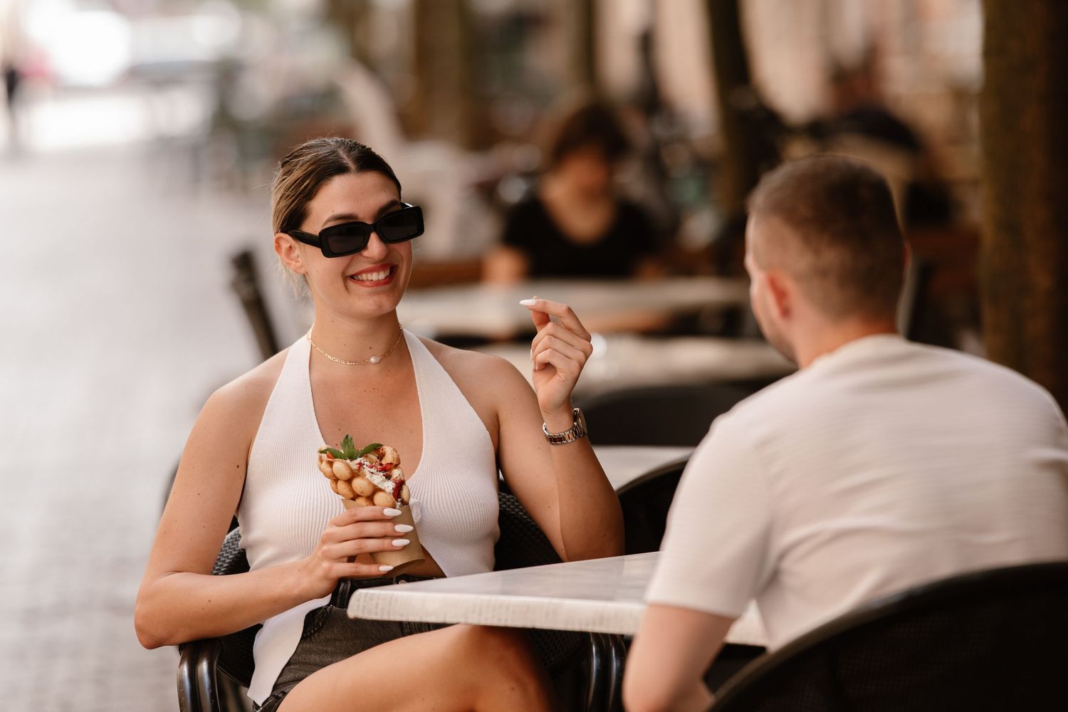 A person in sunglasses enjoys a meal while seated at a casual restaurant table.