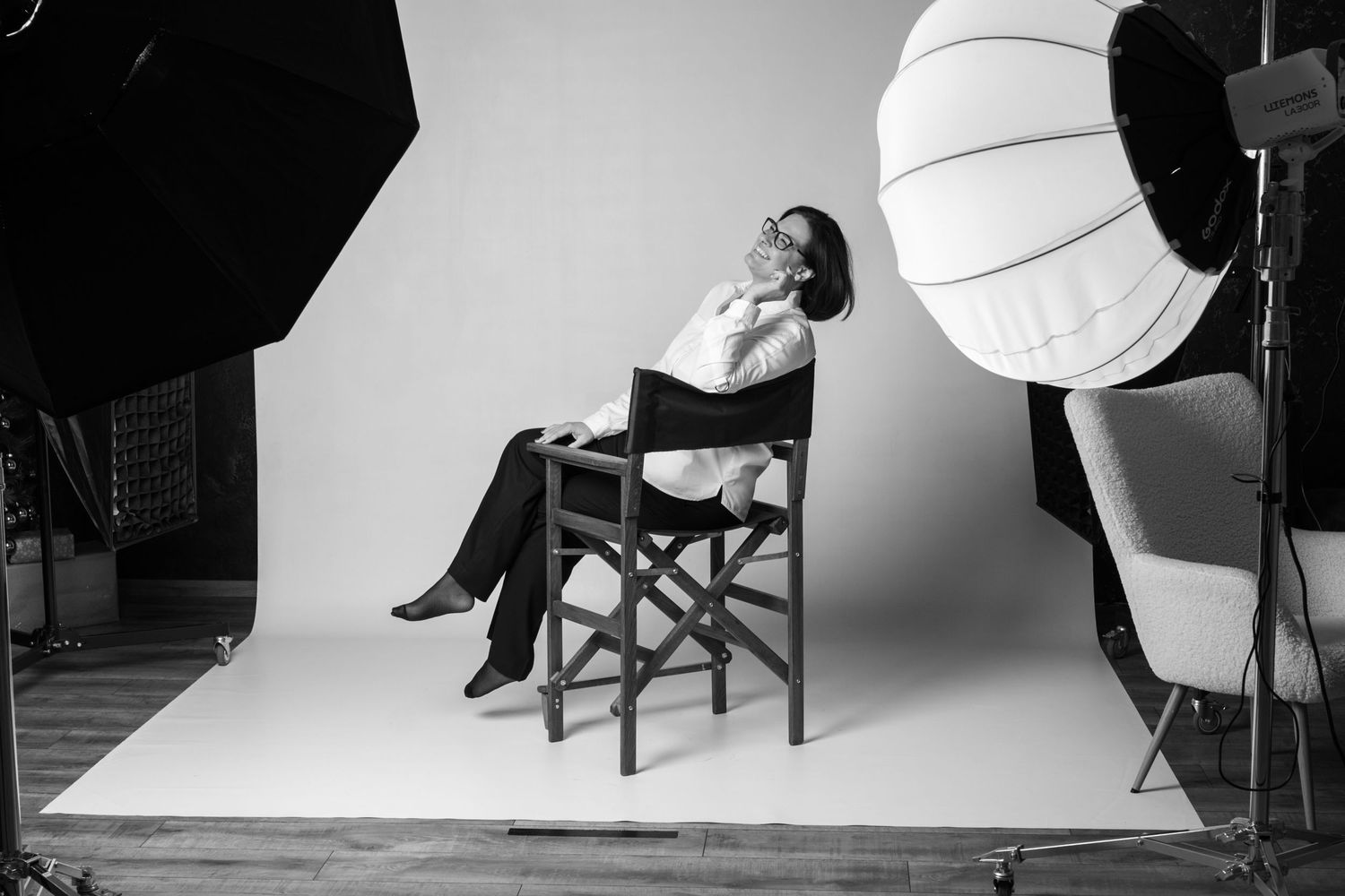 Professional studio photography setup with lighting equipment and chair visible.