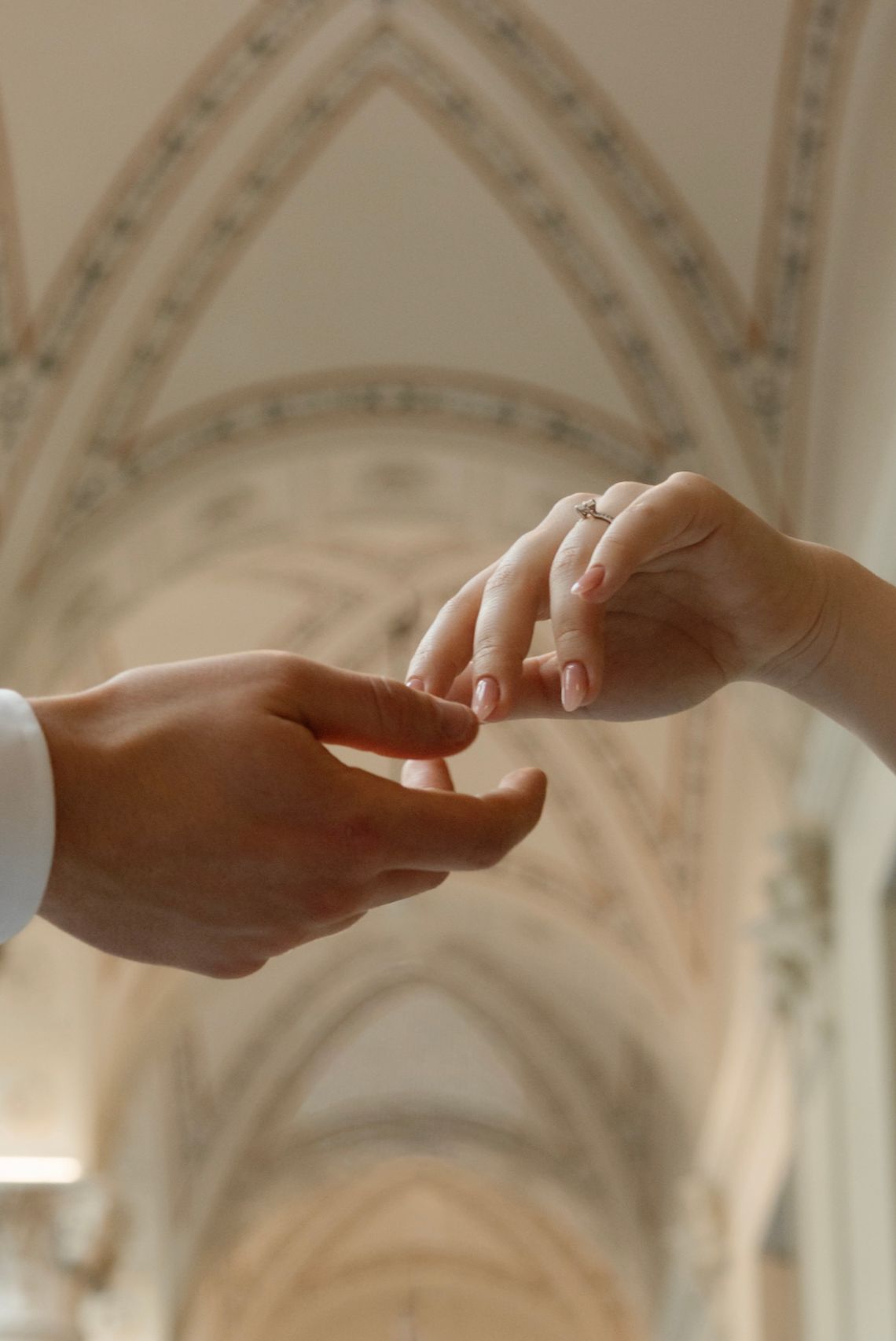 Couple exchanging rings in an elegant Gothic church during a wedding ceremony.
