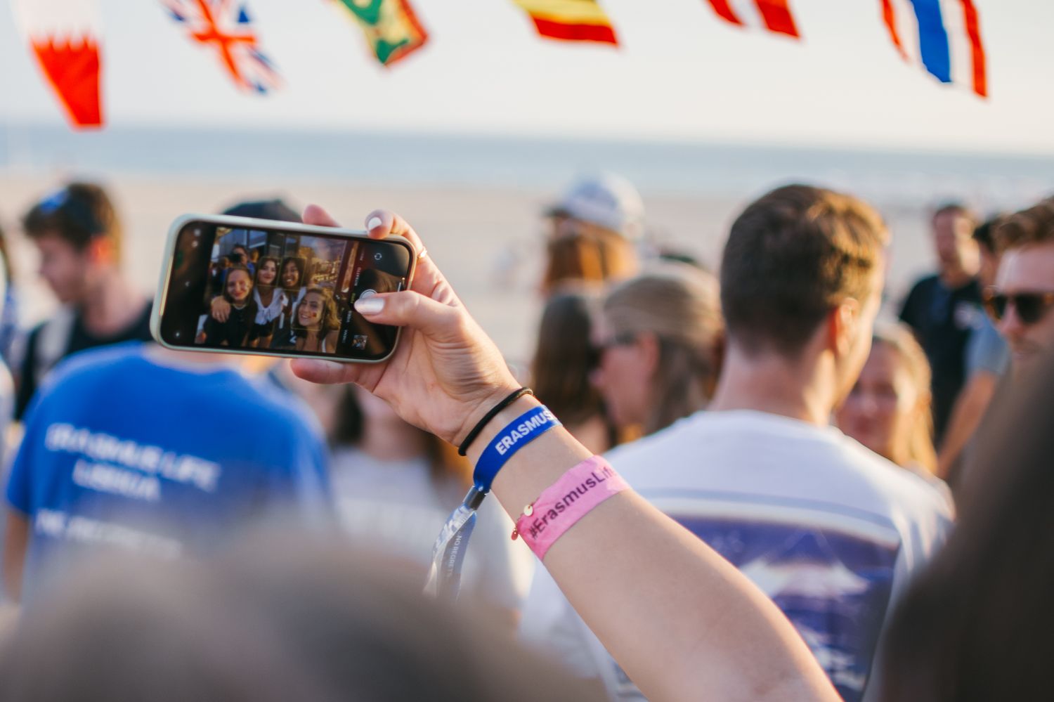 Crowd of people holding up phones at an outdoor event.
