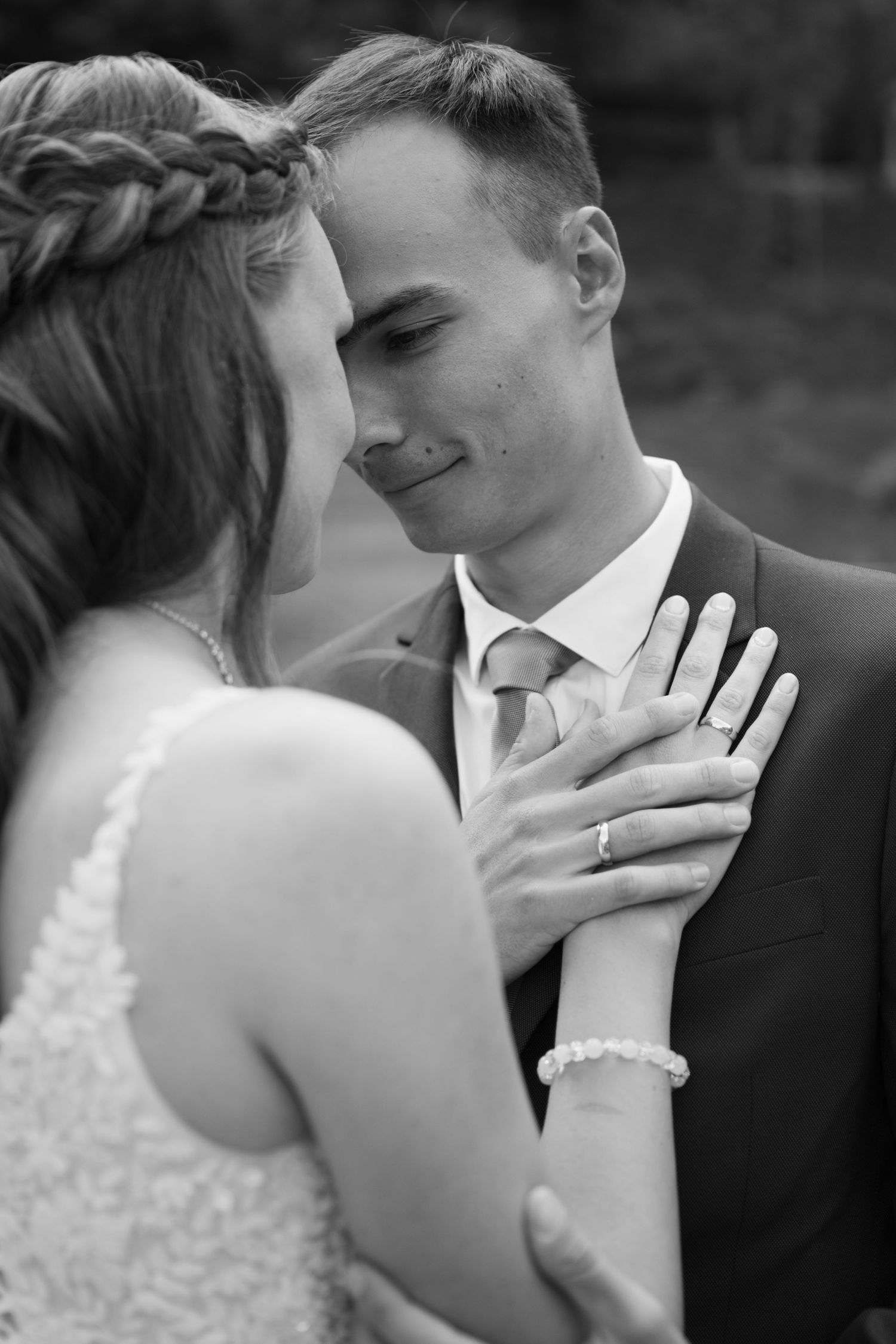 A tender moment between newlyweds as the bride places her hand on the groom's chest, showing off her wedding ring.