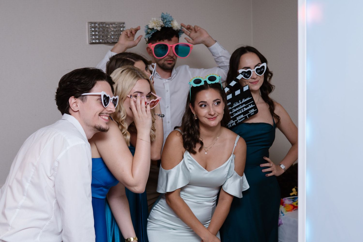Wedding guests pose with fun sunglasses and props at photo booth.