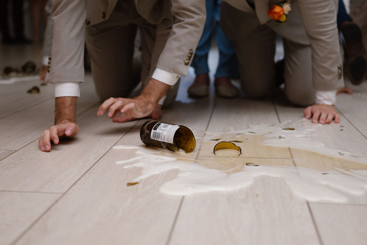 Close-up view of feet and spilled drinks on a white tile dance floor.
