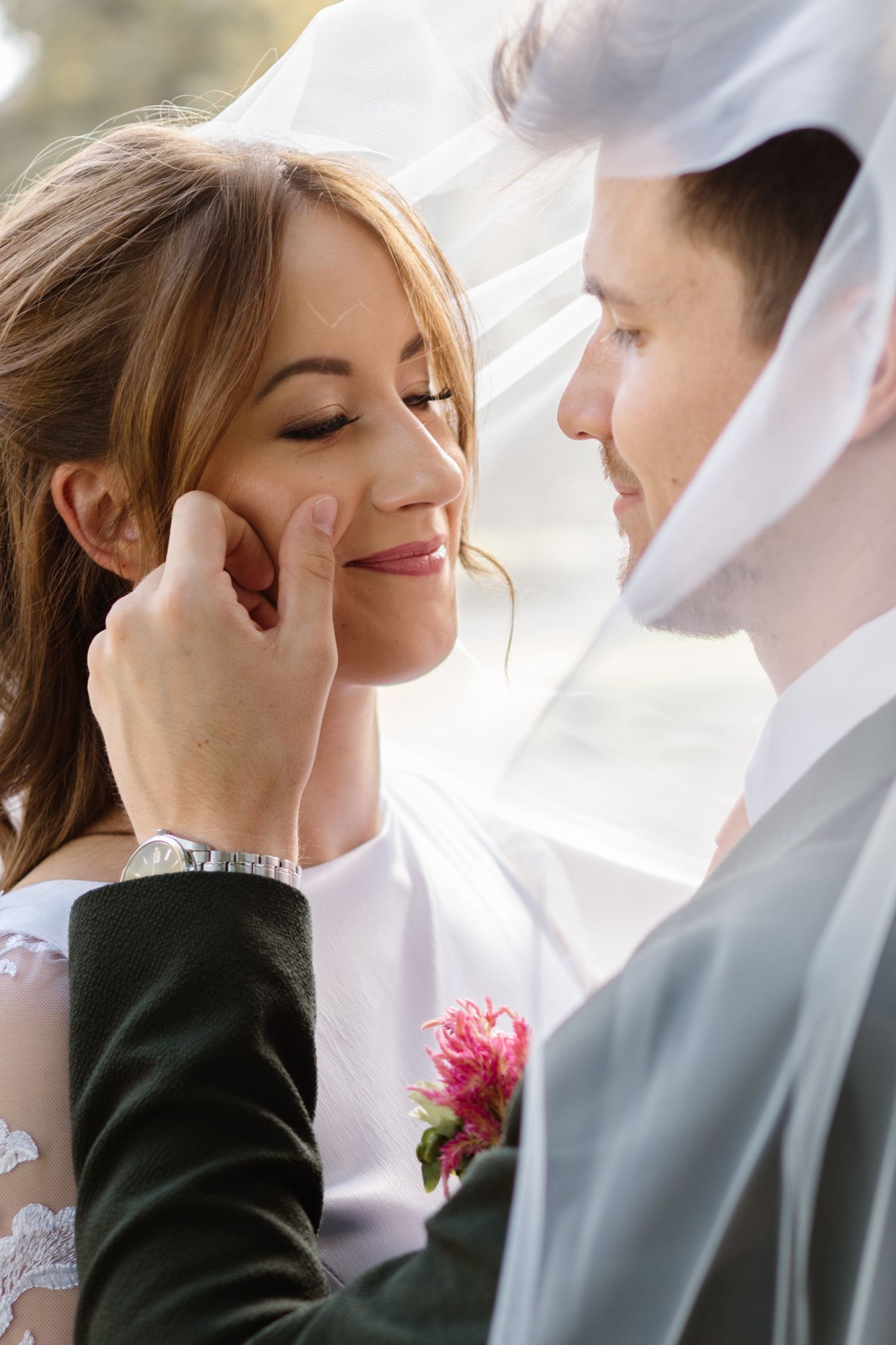 A tender wedding moment captured with soft lighting and delicate veil details.