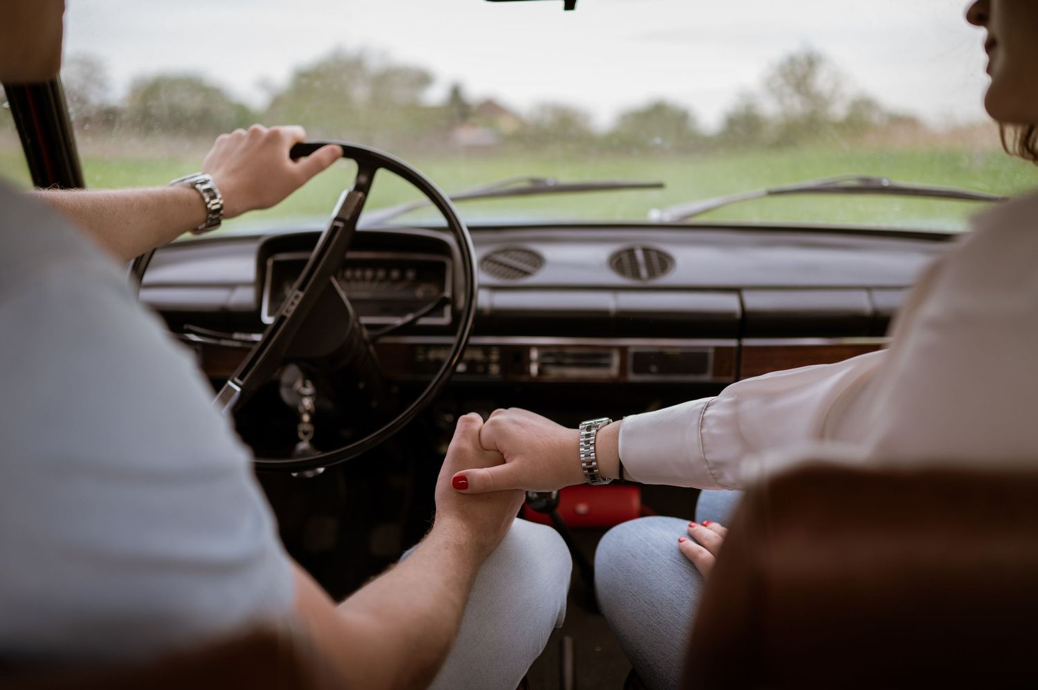 Close-up view through a vintage car windshield on an overcast day.