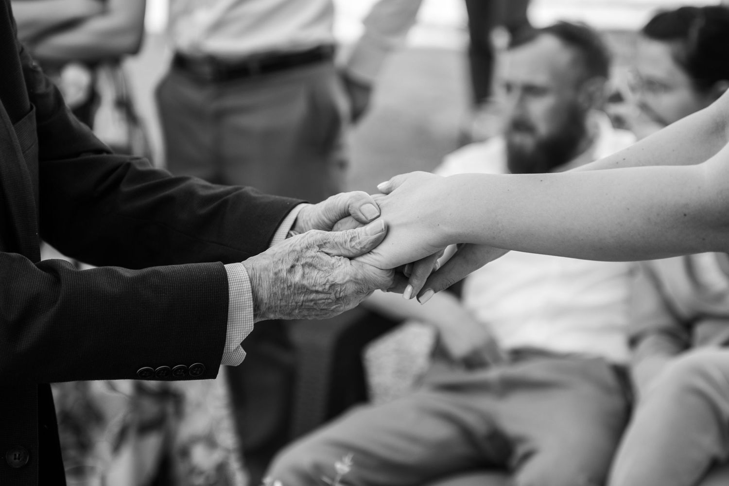 Hands clasped together during emotional wedding ceremony moment.