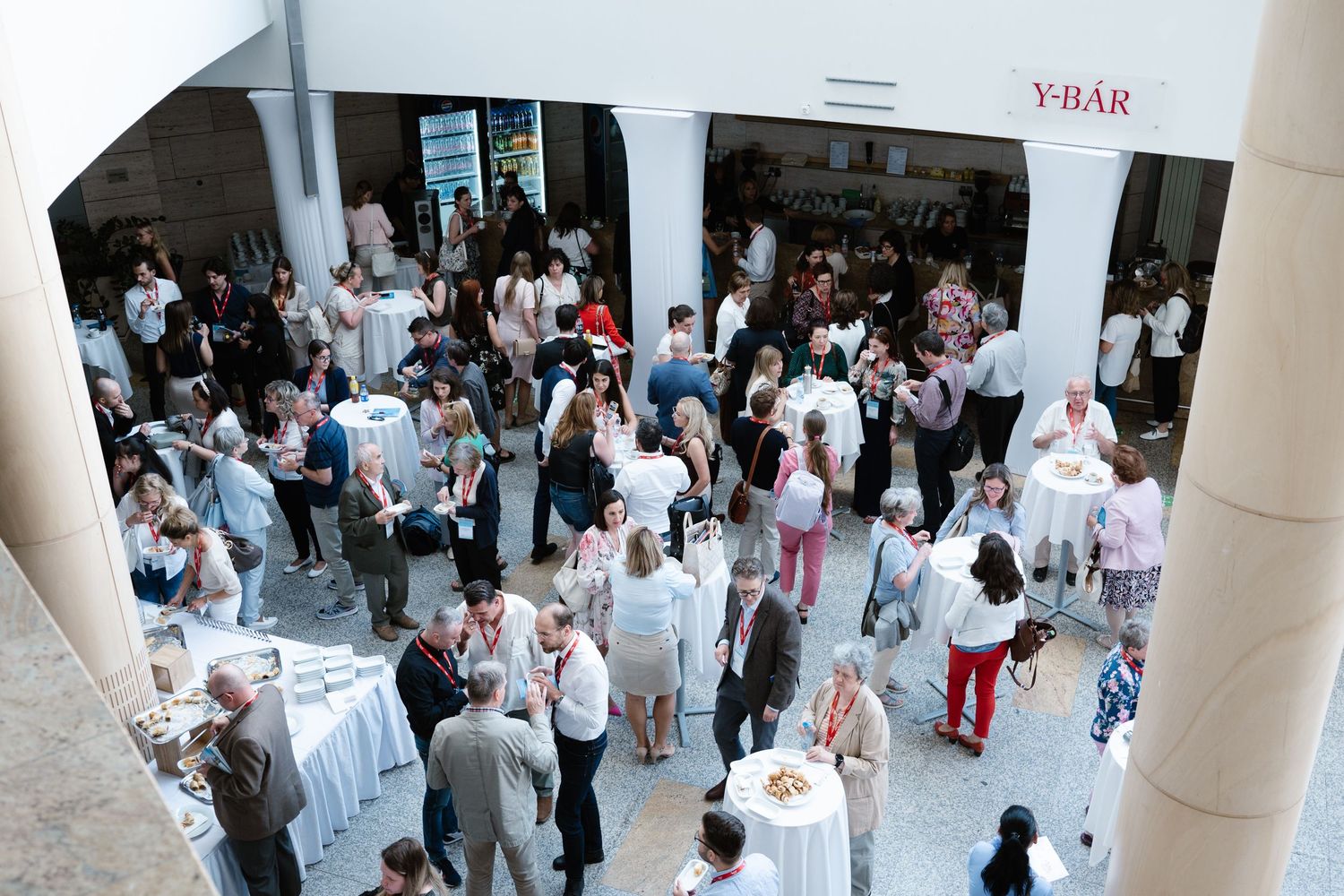 A large crowd gathered in a bright indoor venue hallway.
